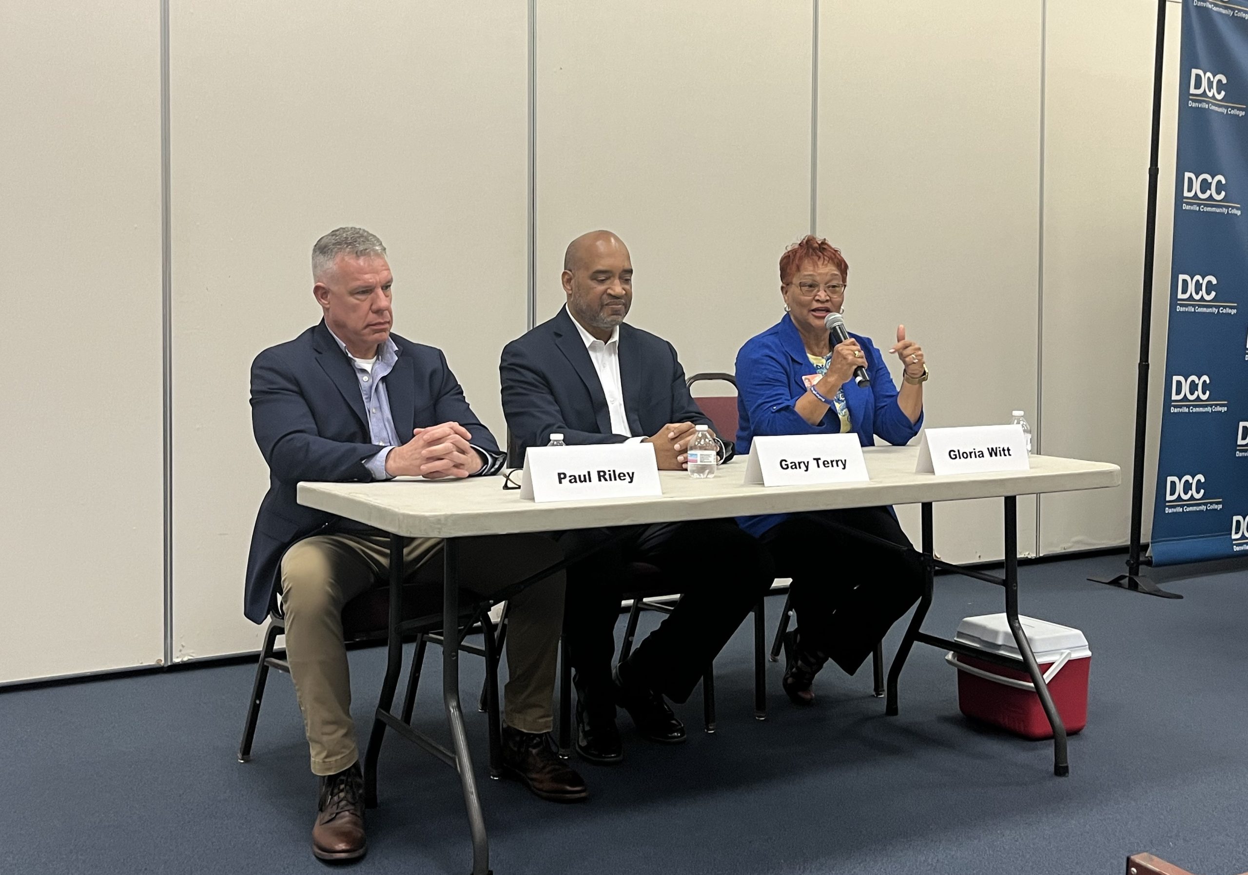 Paul Riley, Gary Terry and Gloria Witt sit at a folding table at an early May candidate forum.