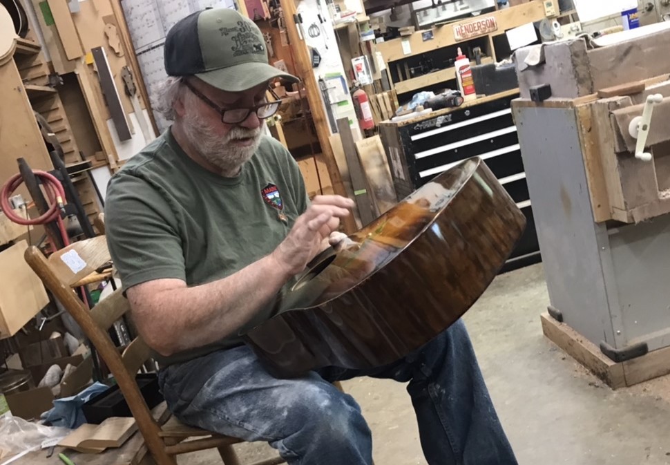 Guitar builder Wayne Henderson taps the wood of a guitar he is making in his Grayson County workshop.  Photo by Ralph Berrier Jr.