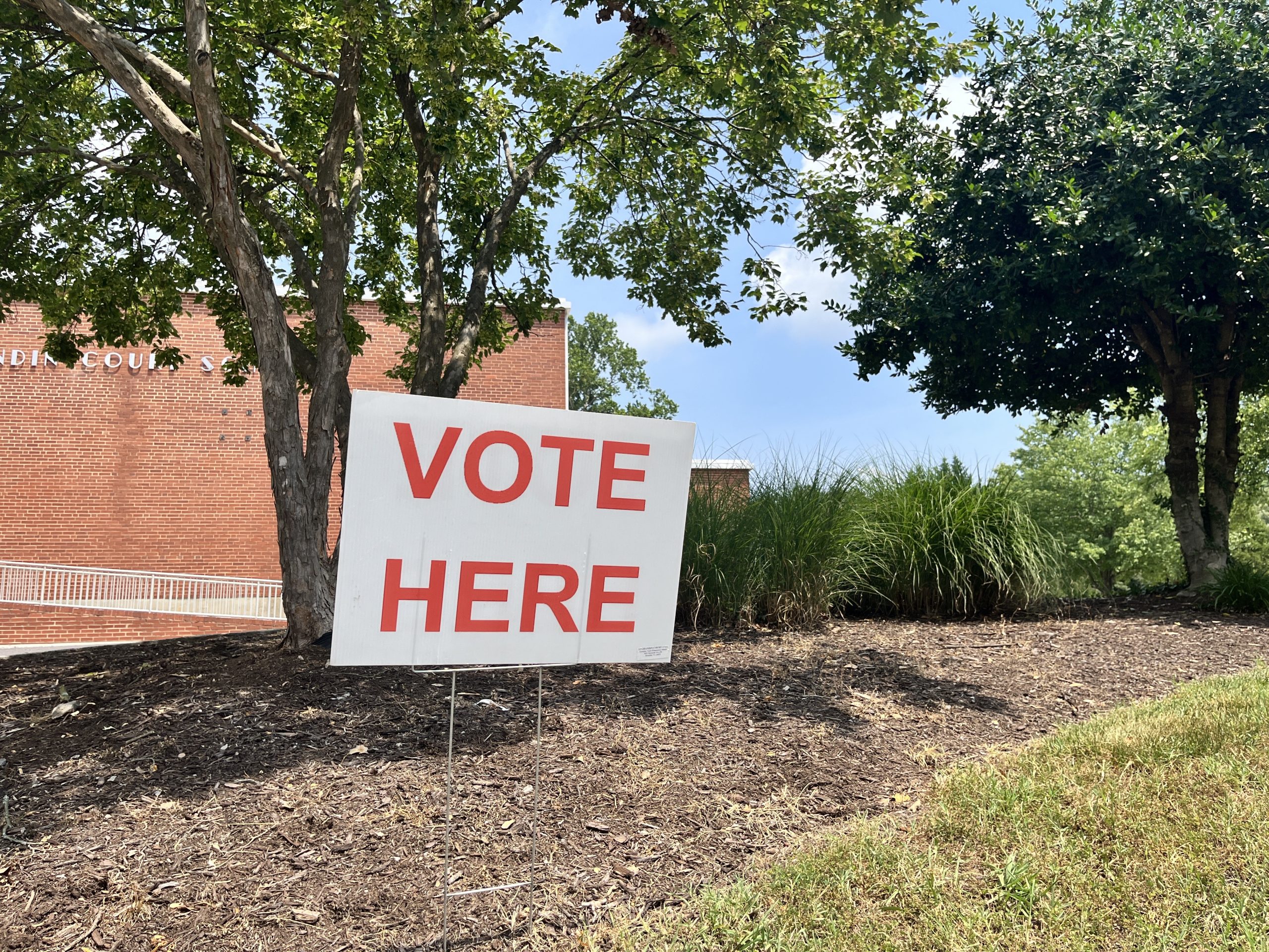 Red and white "Vote here" sign outside Grandin Court Elementary School on June 18, 2024.
