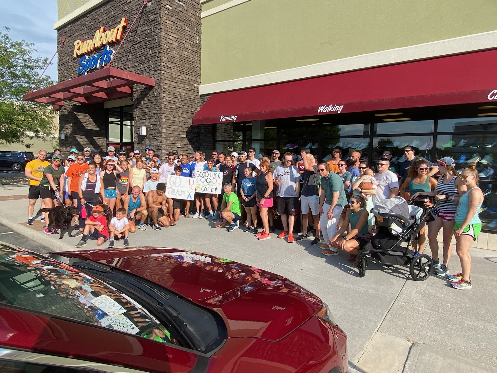 Members of the Blacksburg running community assembled to give Cole Hocker a farewell for his trip to Paris for the Summer Olympics. Hocker is in the white shirt behind the "Good Luck" sign. Photo by Robert Anderson.