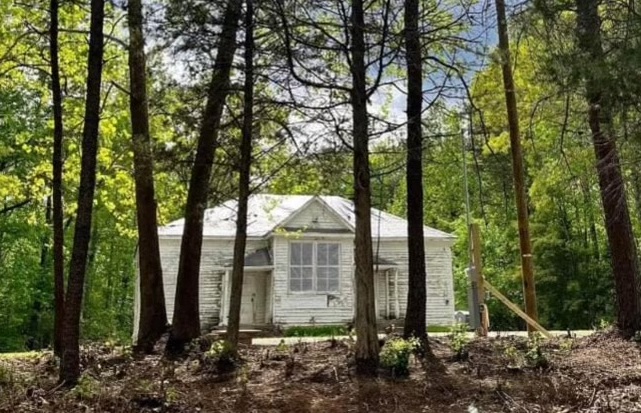The Pine Grove school in Cumberland County, an old white-frame single-story building surrounded by trees.