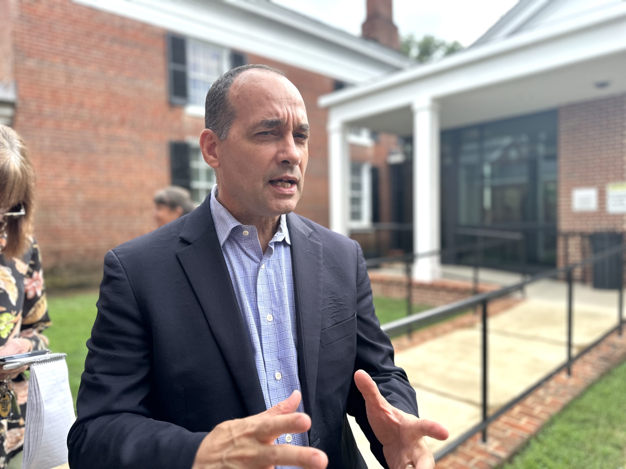 Bob Good wears a blue blazer and blue shirt, standing outside the Goochland County courthouse.