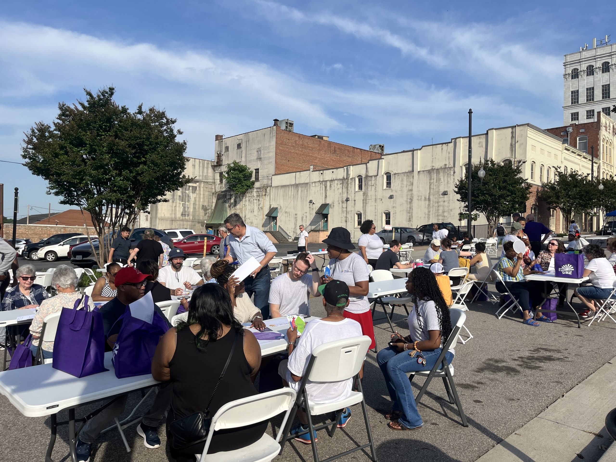 Groups of people sit around fold out tables set up on North Union Street in Danville's River District.