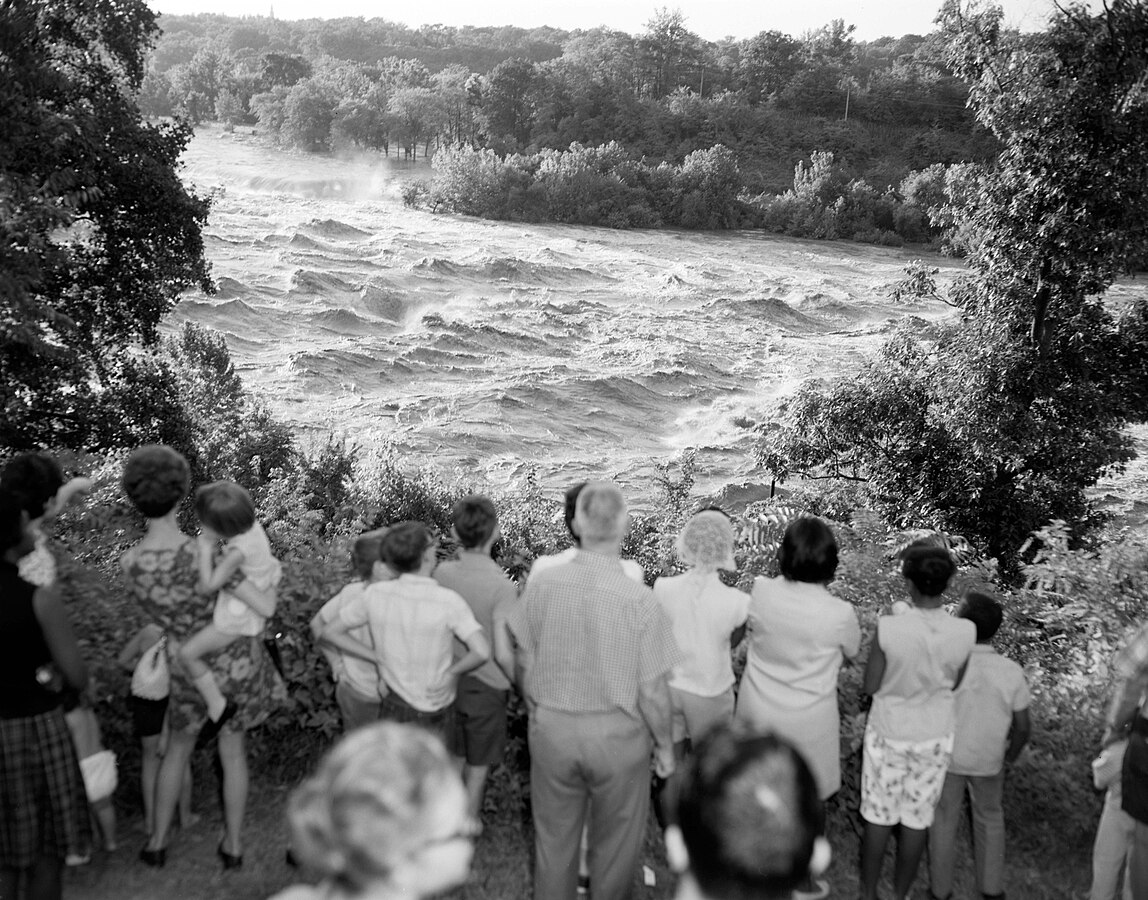 People gather to watch the atypically turgid waters of the James River surge through Richmond in August 1969 after the extreme rainfall from the remnants of Hurricane Camille poured down the Blue Ridge from in and around Nelson County into the James River basin. Incredibly, the James River would break its record crest at Richmond just three years later with the remnants of Hurricane Agnes. Courtesy of Library of Virginia.