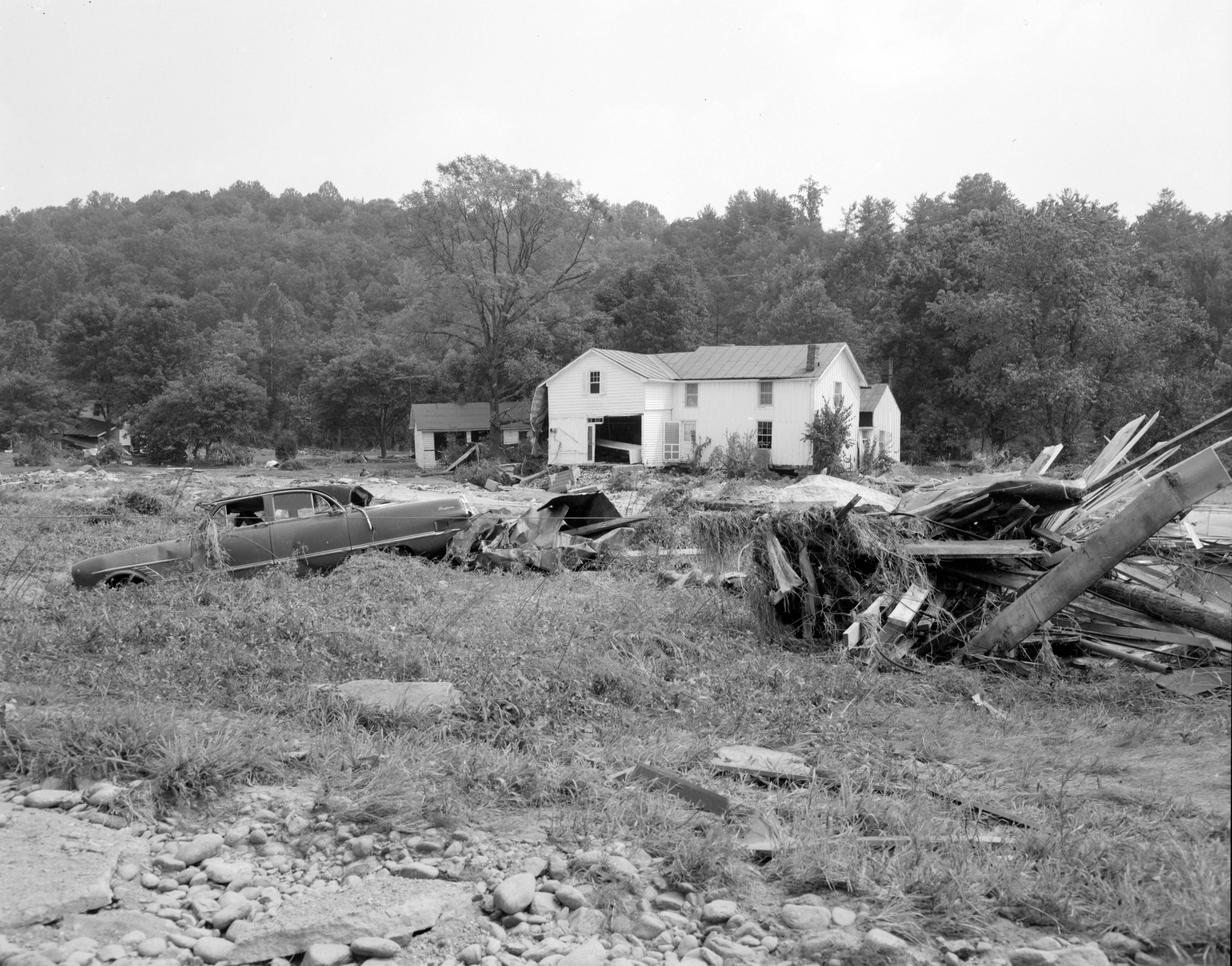 Masseys Mill was one of the hardest-hit communities in Nelson County during 1969 flooding from Camille. Debris was strewn throughout a flood plain in front of a heavily damaged house. Courtesy of Library of Virginia.