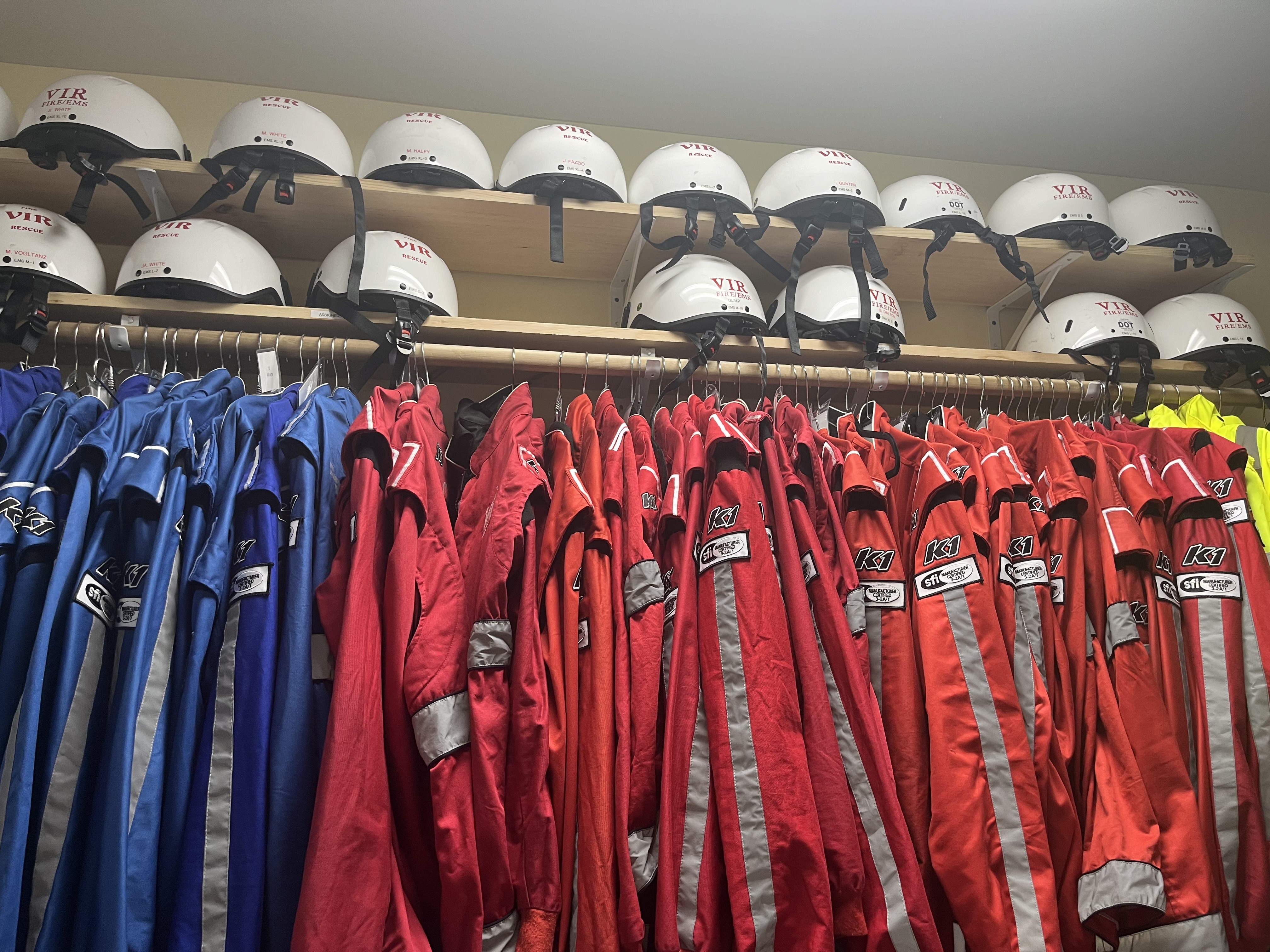 Red and blue jackets hang underneath helmets in the staff room for the fire and EMS personnel staff at Virginia International Raceway