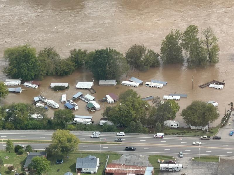 A trailer park inundated with muddy flood waters, as seen from the air.