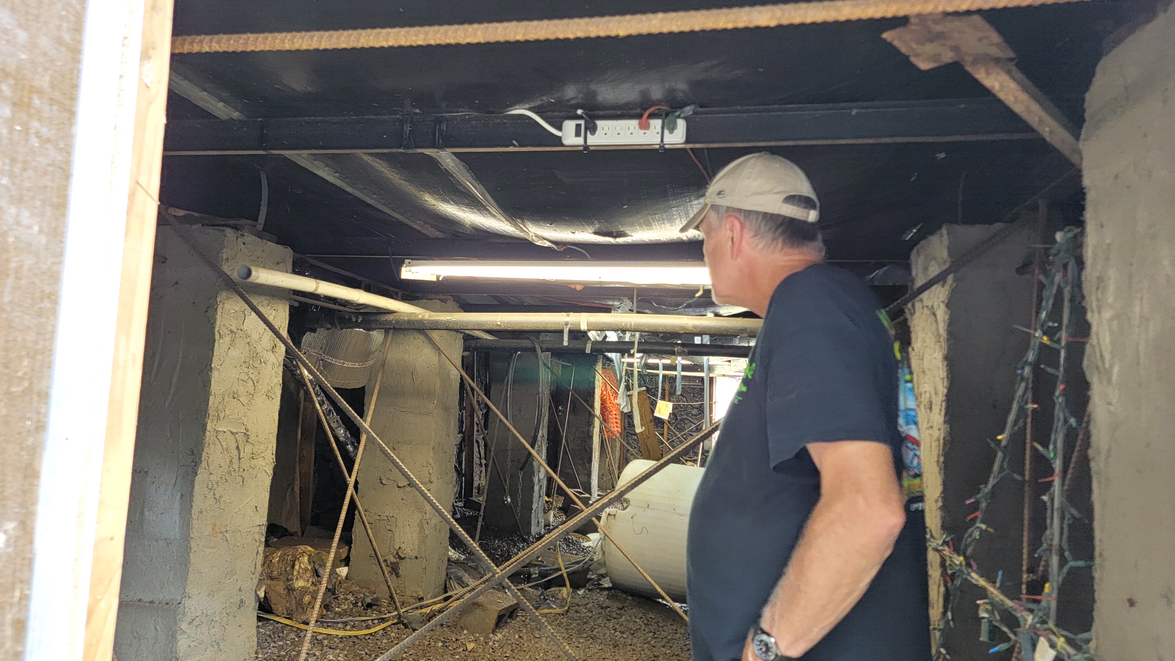 Sandy Collins surveys the water-soaked insulation under his raised trailer home on Cliff View Drive in Pembroke.