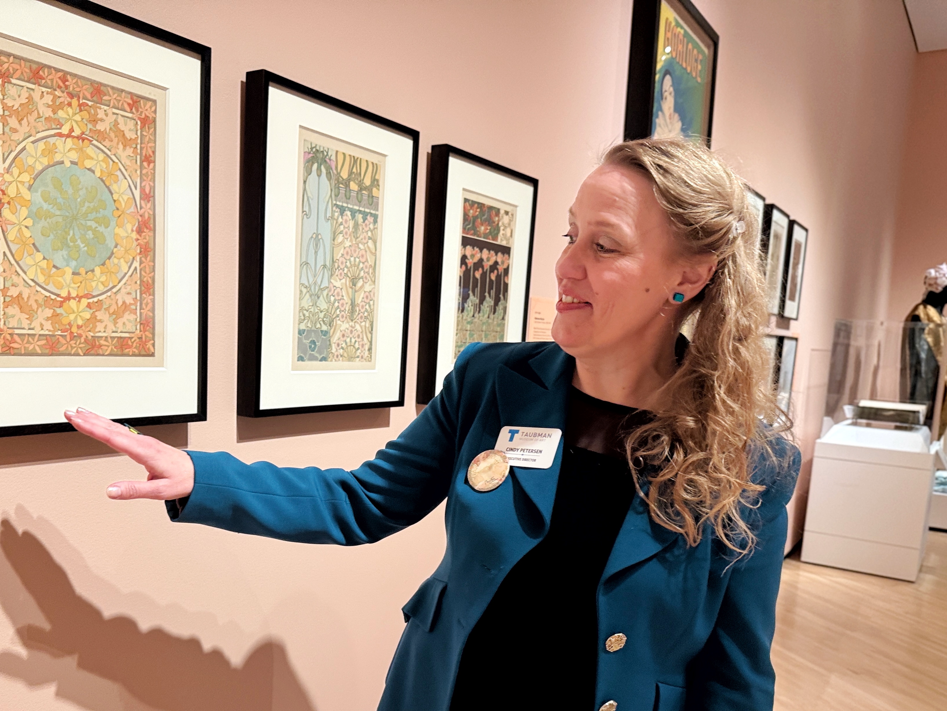 Cindy Peterson, Tubman museum curator, points out the themes in artwork by an Art Nouveau period painter.
