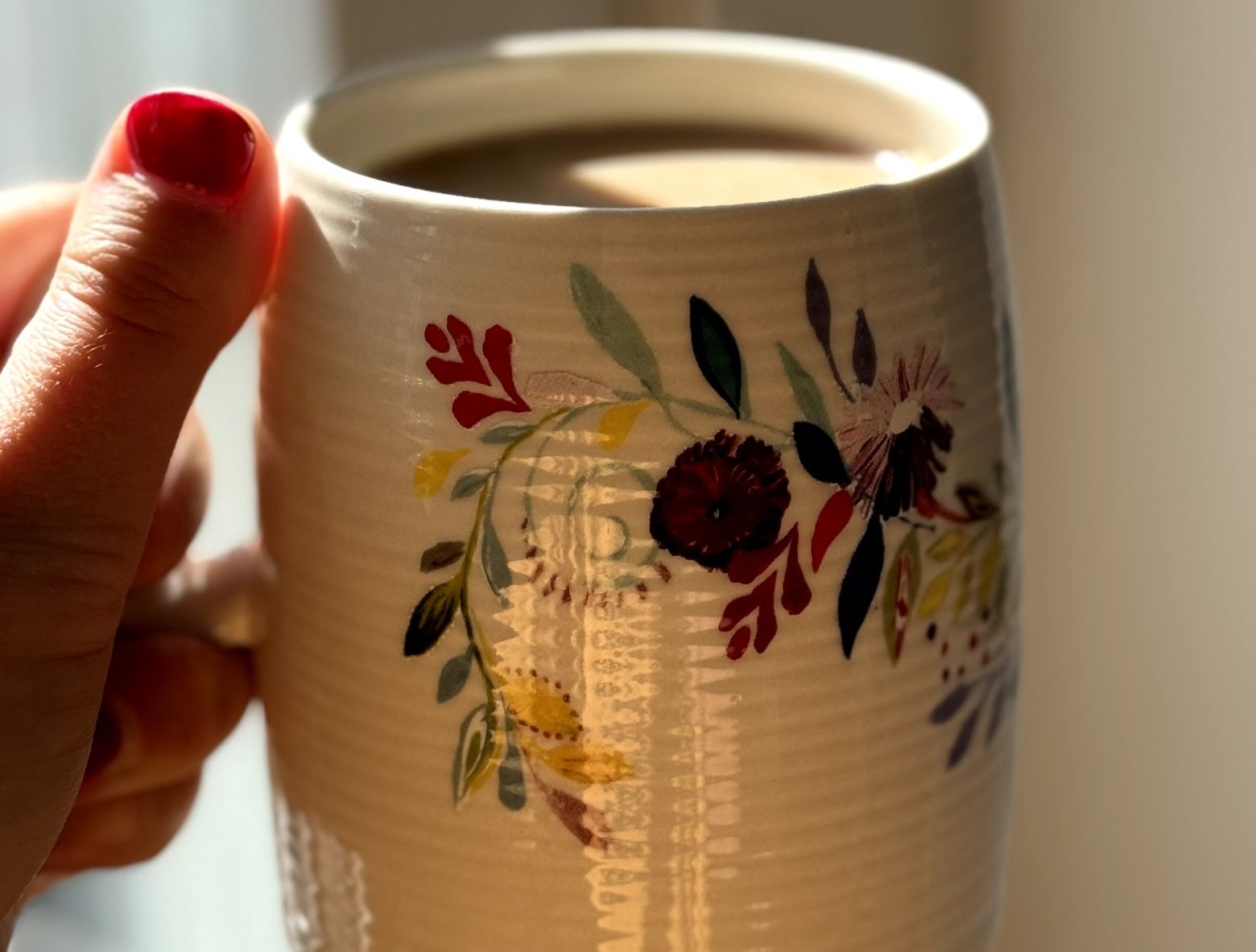 A hand holding a cup of coffee.