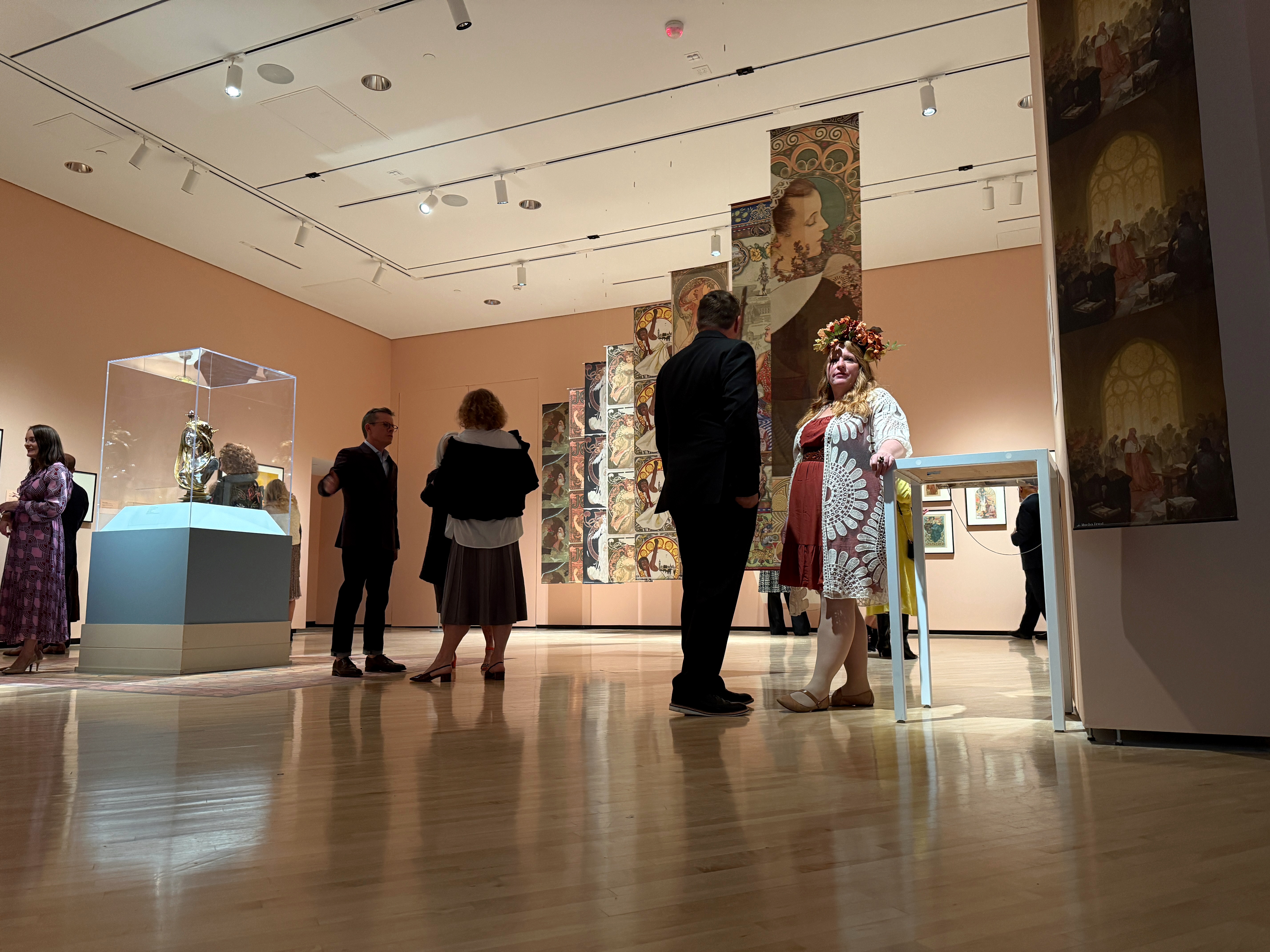 A man and a woman stand by vertical Art Nouveau panels at the Taubman museum.