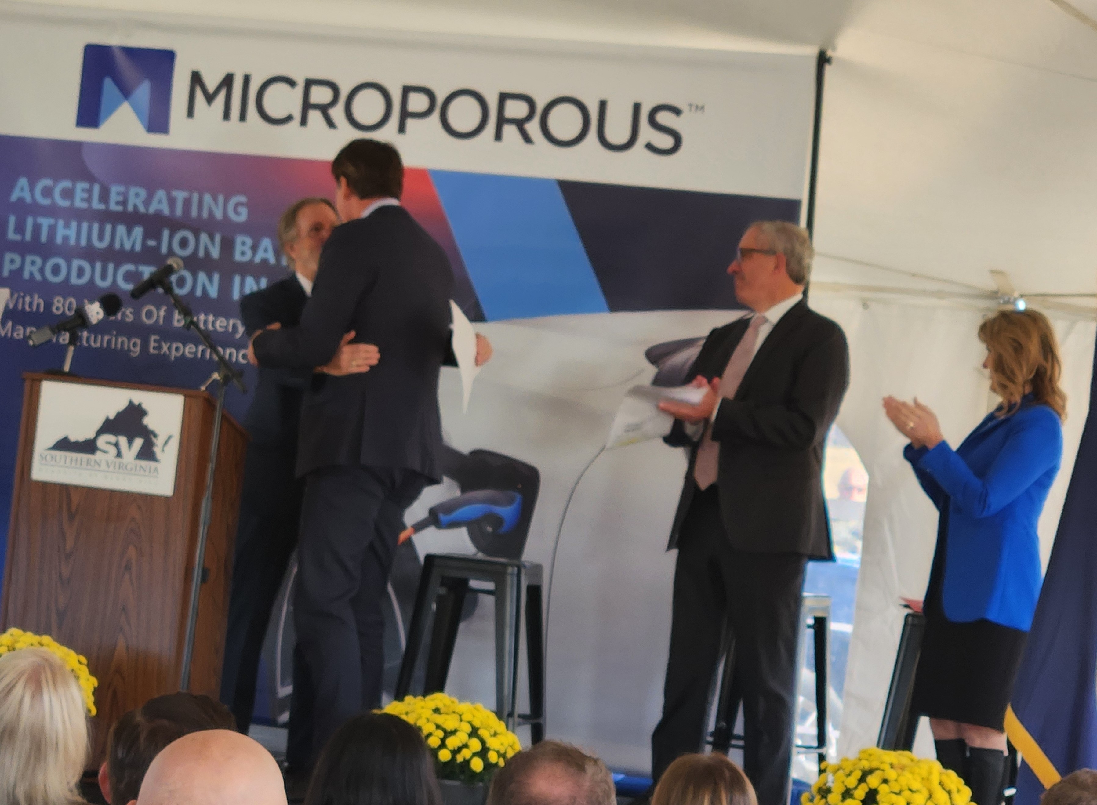 Pittsylvania County Supervisor Vic Ingram hugs Gov. Glenn Youngkin At right is Microporous CEO John Reeves and state Secretary of Commerce and Trade Caren Merrick. Photo by Dwayne Yancey