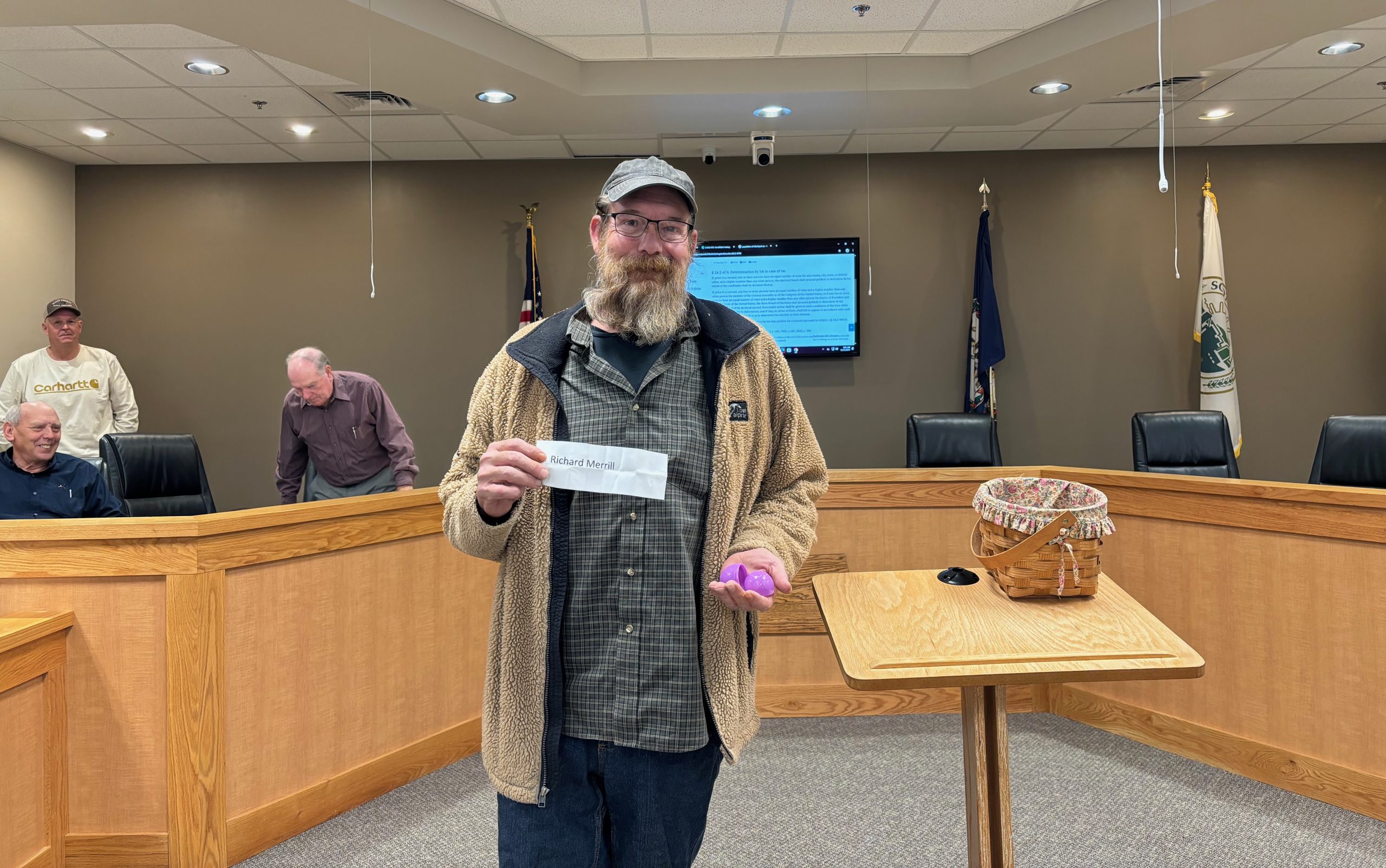 Newly elected Clinchport Town Council member Richard Merrill holds his winning egg while electoral board members look on. Photo by Katie Thomason.