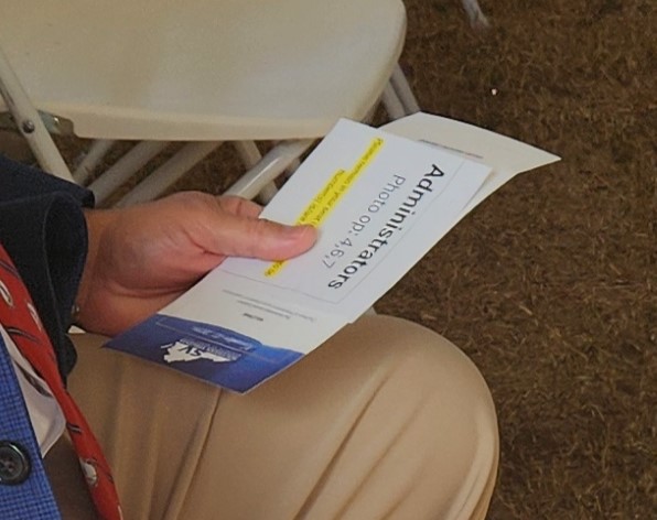 A government official holds the card that designates which group he's in for photos. Photo by Dwayne Yancey
