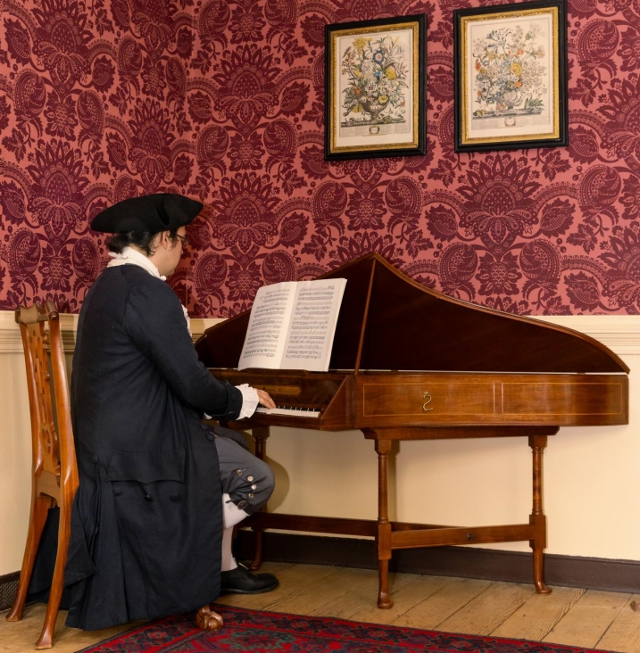 Music interpreter Kyle Collins plays a harpsichord in Colonial Williamsburg. Photo: Brendan Sostak, The Colonial Williamsburg Foundation.