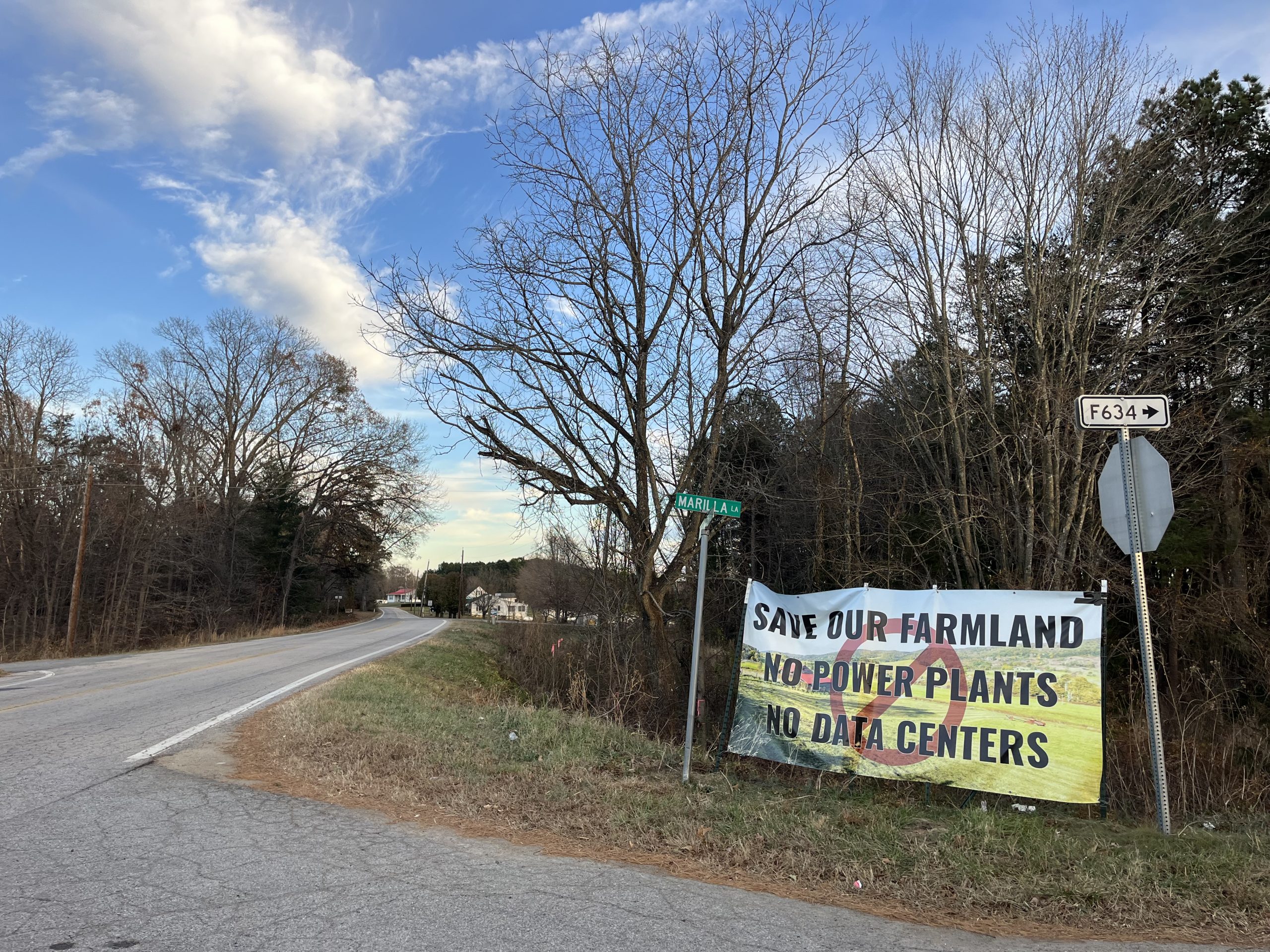 a sign on the side of a rural backroad that reads "Save our farmland. No power plants. No data centers."