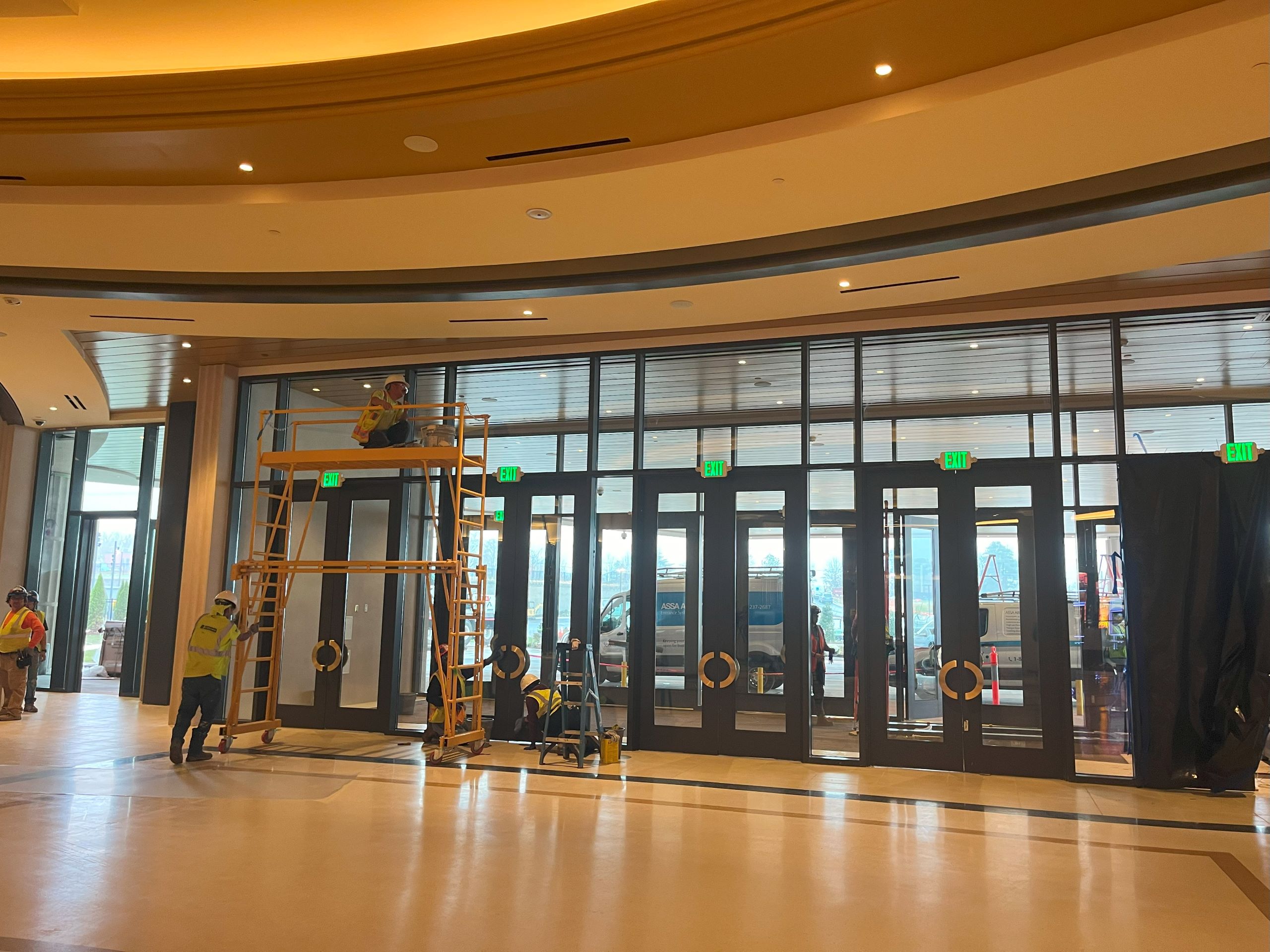 construction employees working on finishing touches around the glass front doors of the casino.