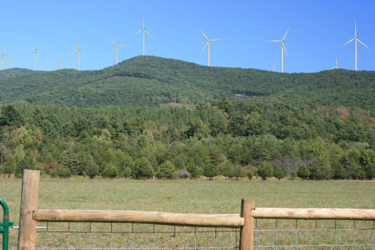 a rendering of wind turbines on a distant green hill