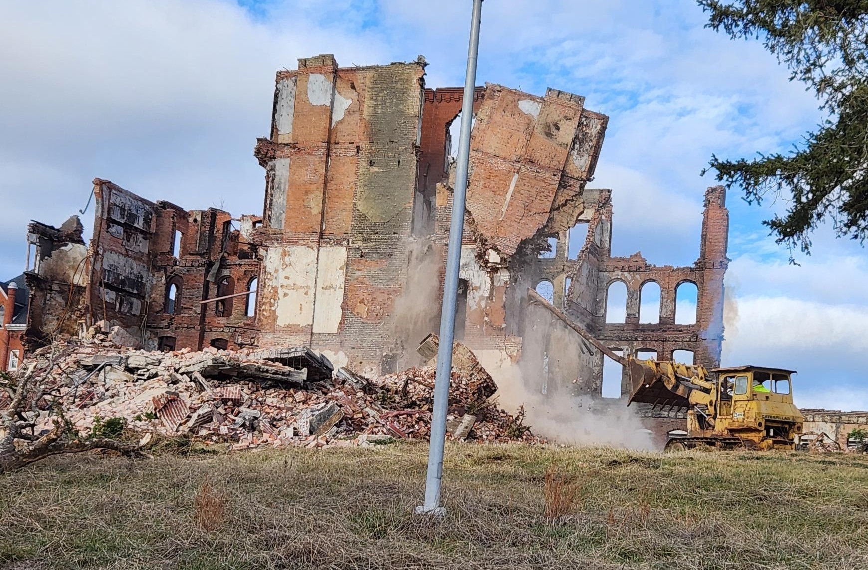 One of the walls left of the buildings destroyed by a Dec. 20 fire at the former Virginia Intermont College campus in Bristol is coming down as demolition crews started working this week.