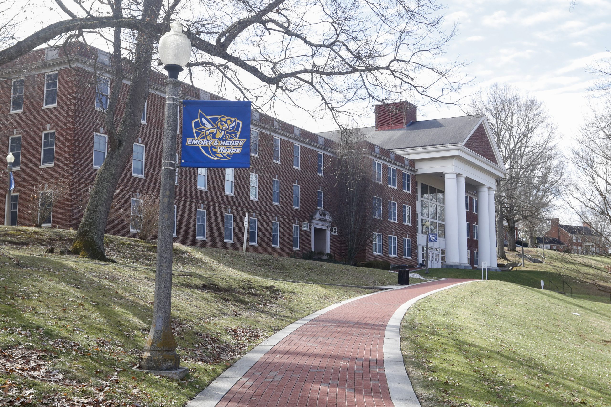 The exterior of a red brick building with white columns at Emory & Henry