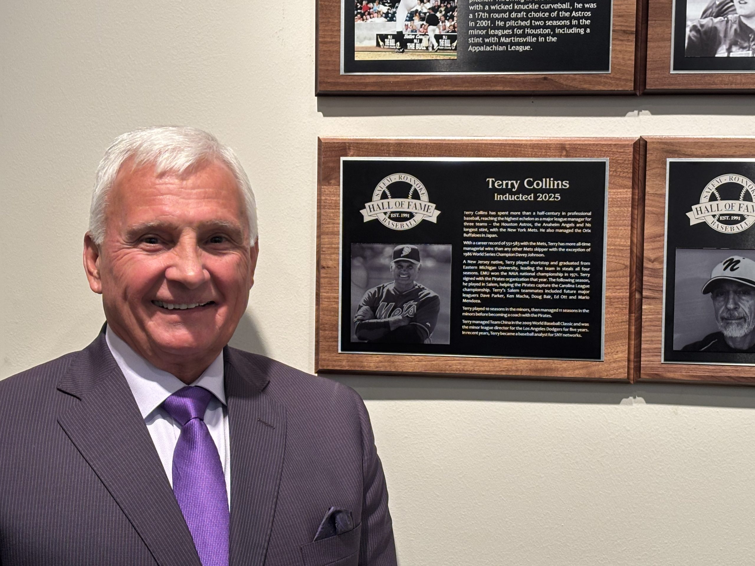 Terry Collins, a retired major league manager who led the 2015 New York Mets to the World Series, stands next to the plaque commemorating his induction into the Salem-Roanoke Basketball Hall of Fame on Sunday, Feb. 2, 2025. Photo by Steve Hemphill.