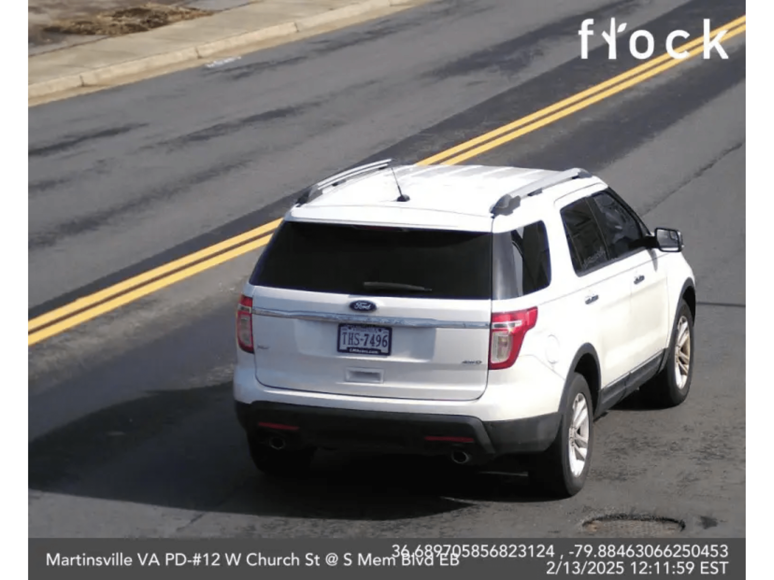 A white Ford Explorer seen from behind, driving on a road with double yellow lines in Martinsville, VA, February 2025.