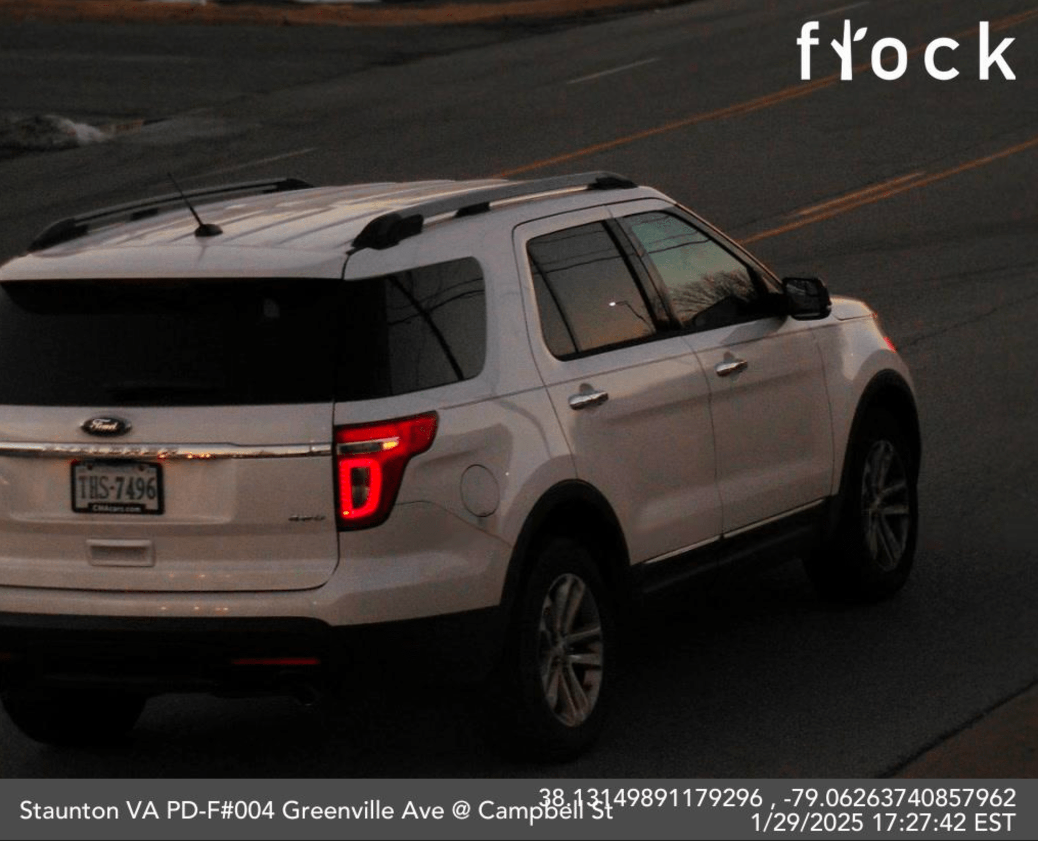 The back of a white car is photographed around dusk in January by a Flock Safety license plate reader.