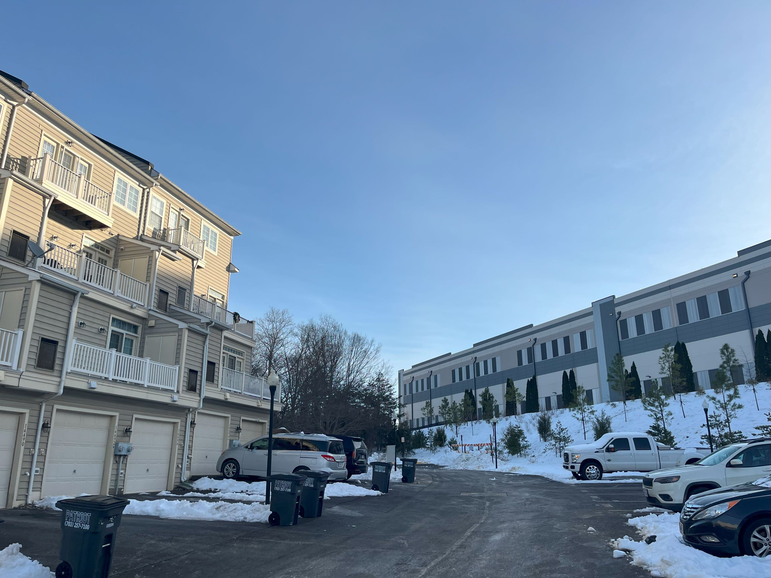 An access road in the Village Place neighborhood in Prince Willaim County, with the back of townhomes on one side and a data center building on the other.