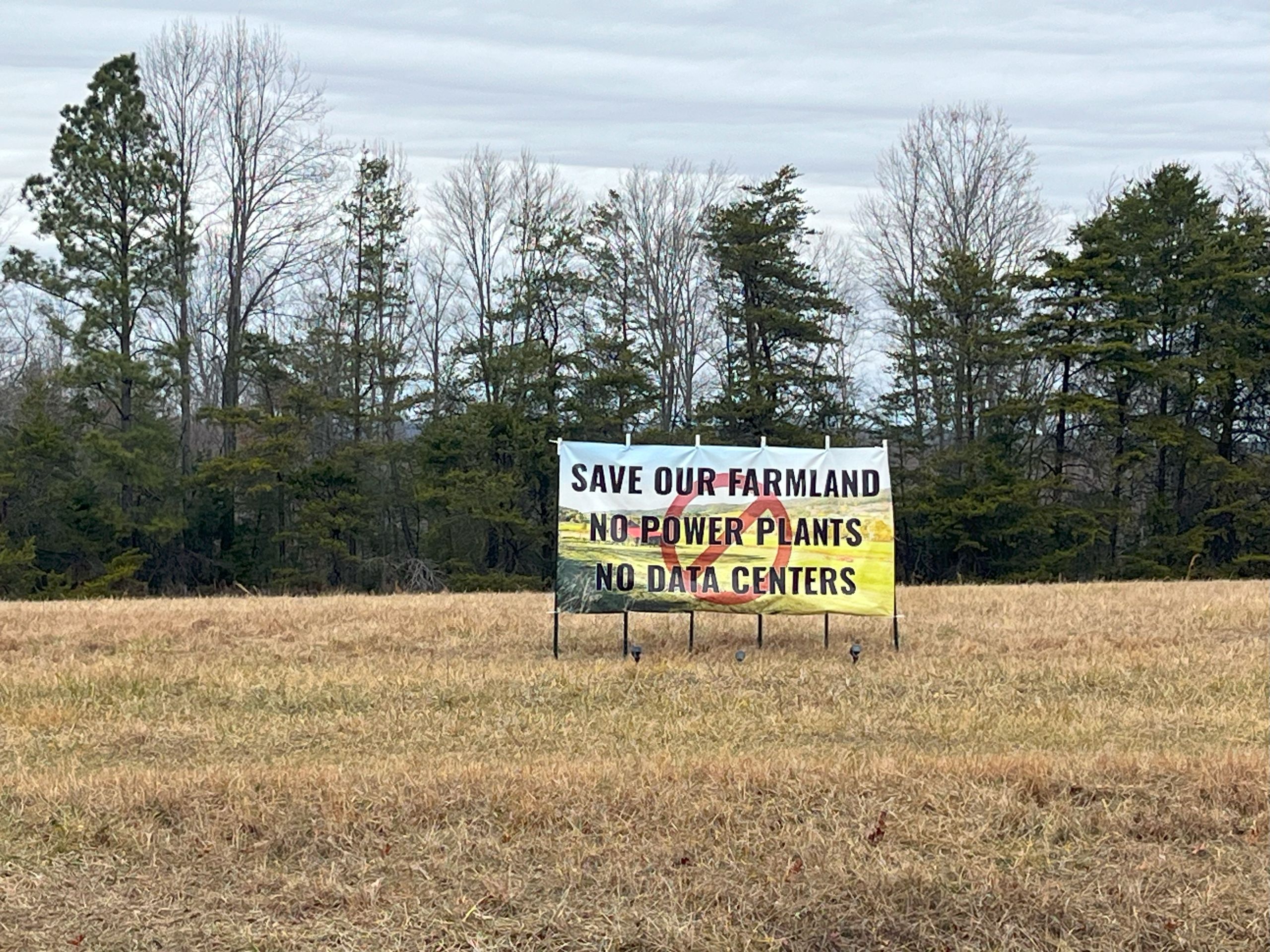 a sign reading "save our farmland, no power plants, no data centers" stands near a backroad in Pittsylvania County