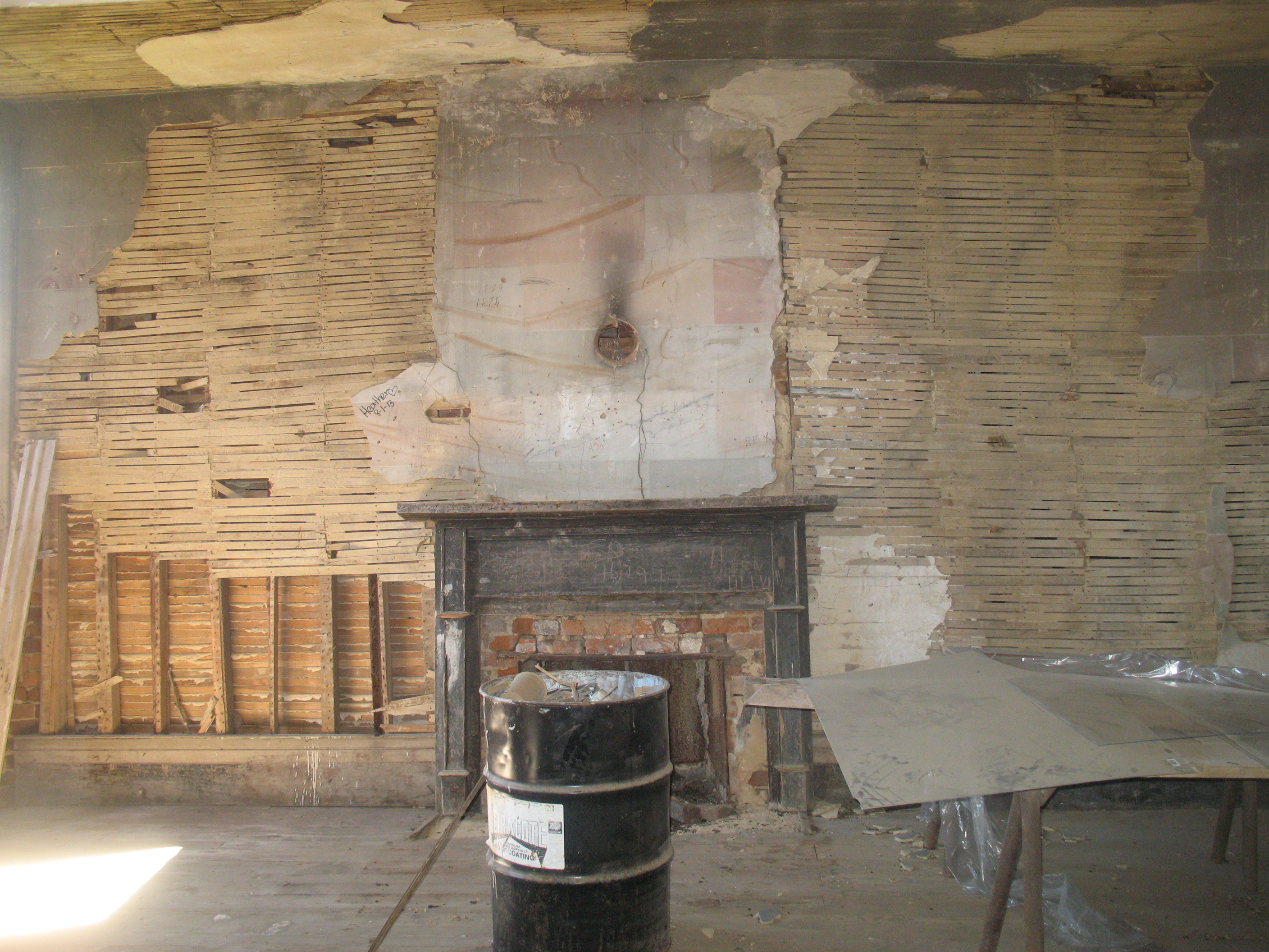 Parlor showing walls and last remaining mantle in the home. This mantle was painted to resemble black marble with white veining, inlayed with glass to reflect the candlelight