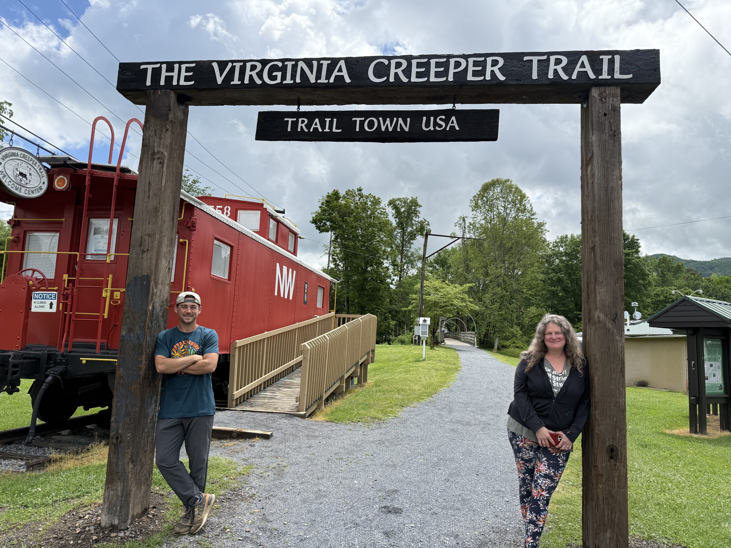 From left, Hunter Faust, vice mayor of Damascus, and Katie Lamb, mayor of Damascus, stand in front new signage for the Virginia Creeper Trail at the Town Park. Photo by Carolyn Wilson.