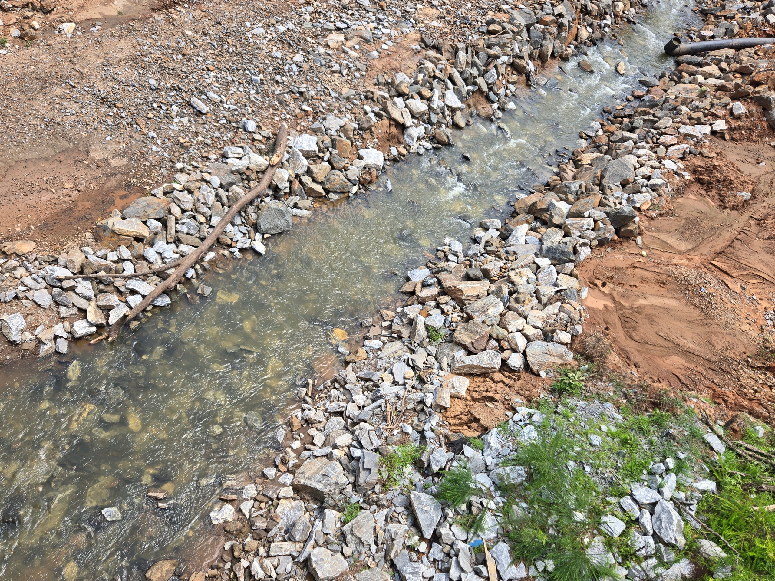 Boulders line the banks of a flowing stream.