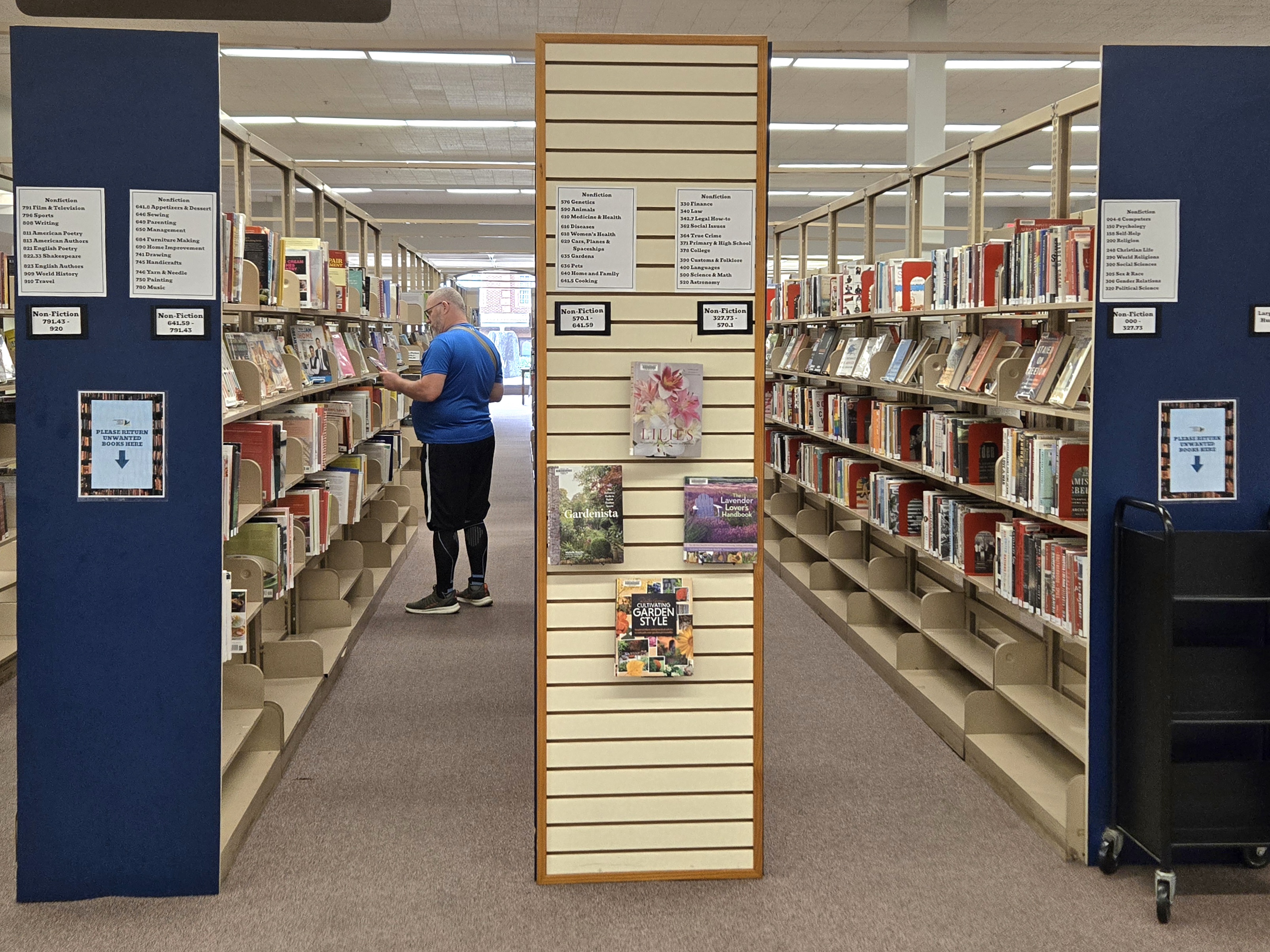 A man looks at a book in the stacks of the Lynchburg Public Library.