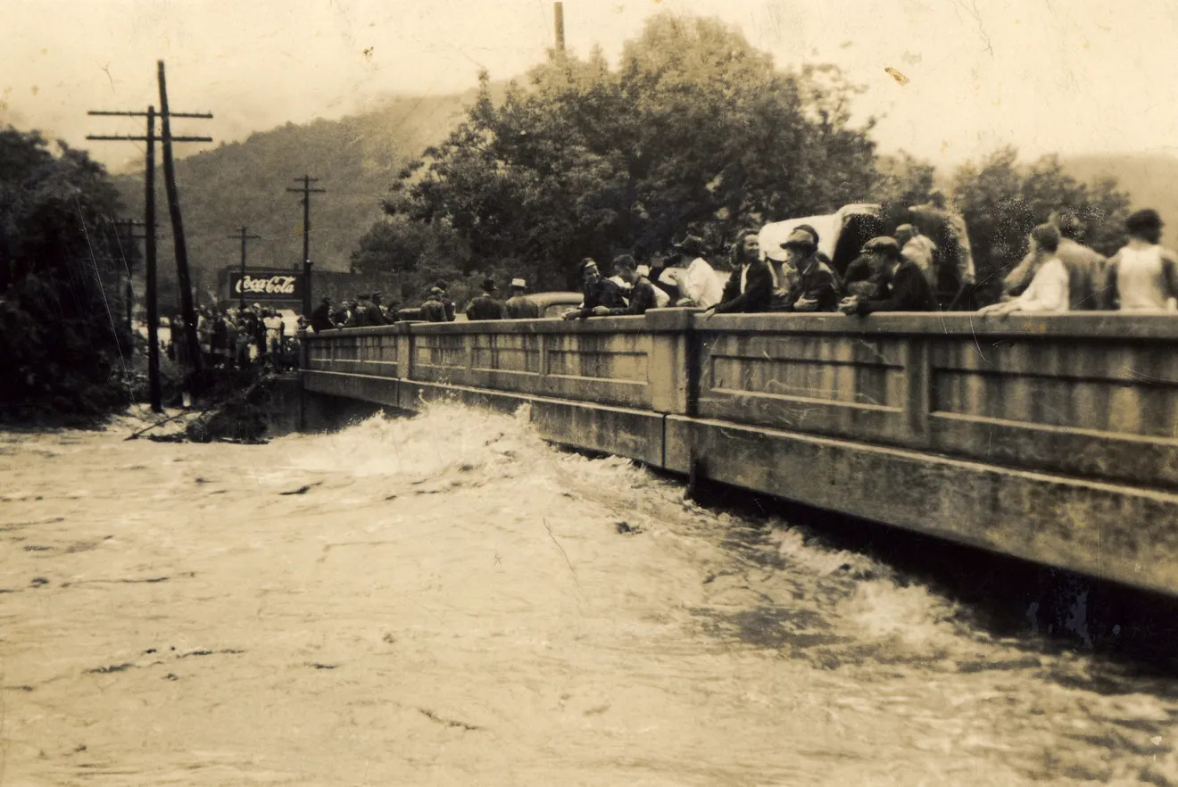Curious onlookers look at the raging high waters of the Swannanoa River off the Whitson Avenue bridge in western North Carolina during the August 1940 flood. Courtesy of the Swannanoa Valley Museum's photo archive.