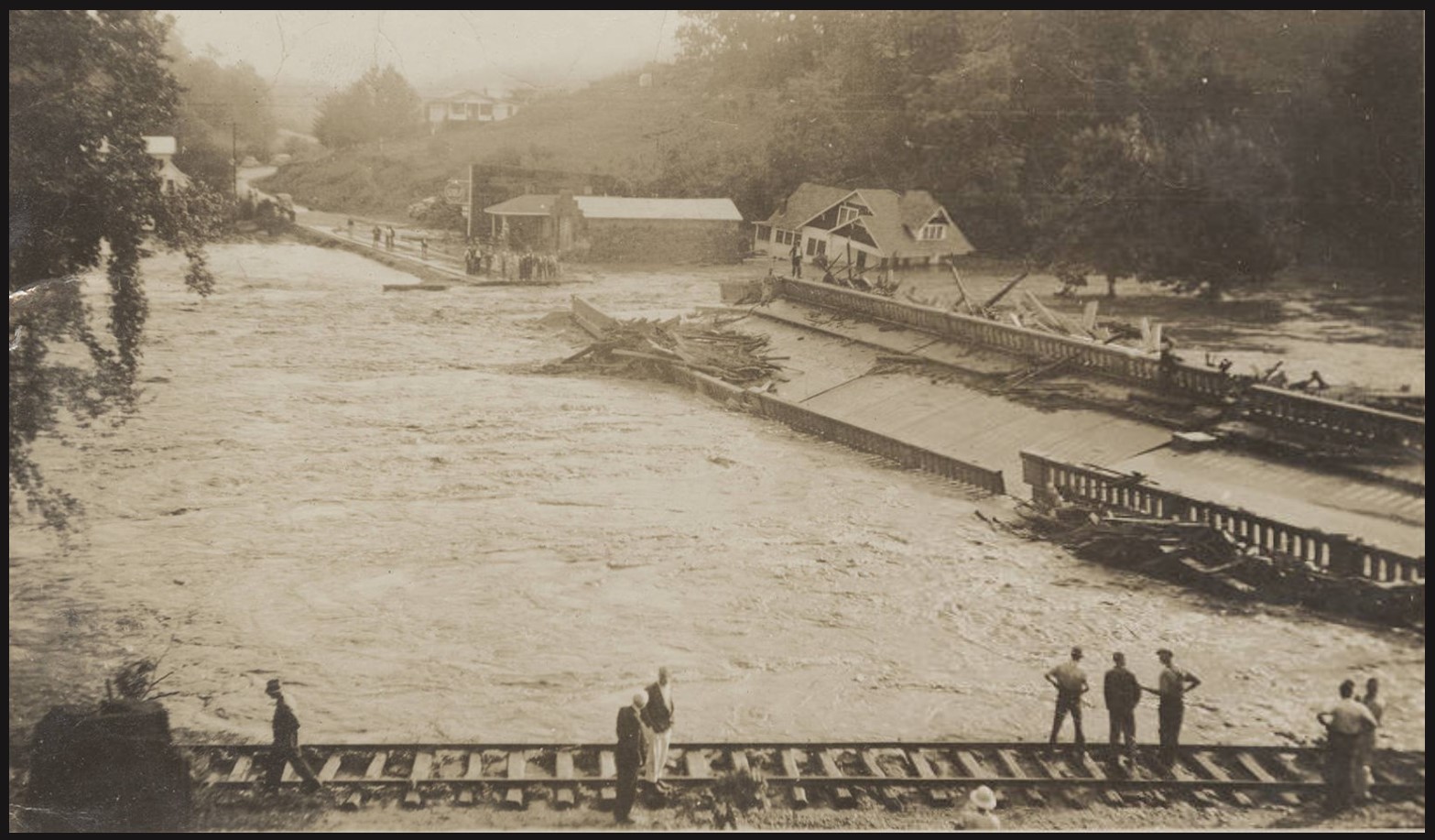 Flooding along the Tuckasegee River damages the Old Cullowhee Road bridge and a railroad track.in Cullowhee, North Carolina, on Aug. 13, 1940. Courtesy of Hunter Library, Western Carolina University.