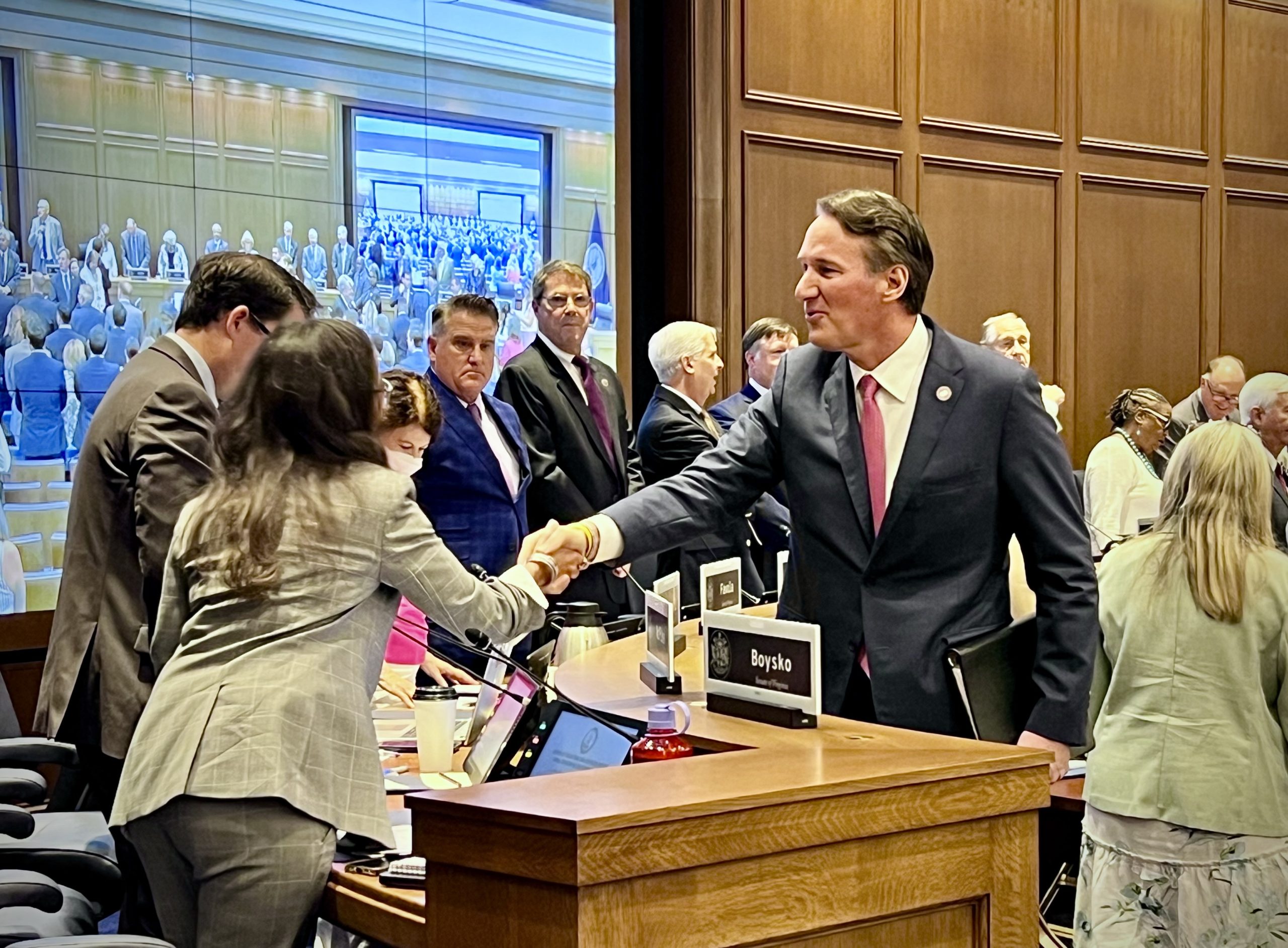 Gov. Glenn Youngkin shakes hands with Sen. Jennifer Boysko, D-Fairfax County, after shaking the hand of every member of the House and Senate Appropriations committees who were in attendance for the bicameral meeting. Youngkin provided his annual update on the fiscal status of the state to the joint money committee Thursday morning. Photo by Elizabeth Beyer