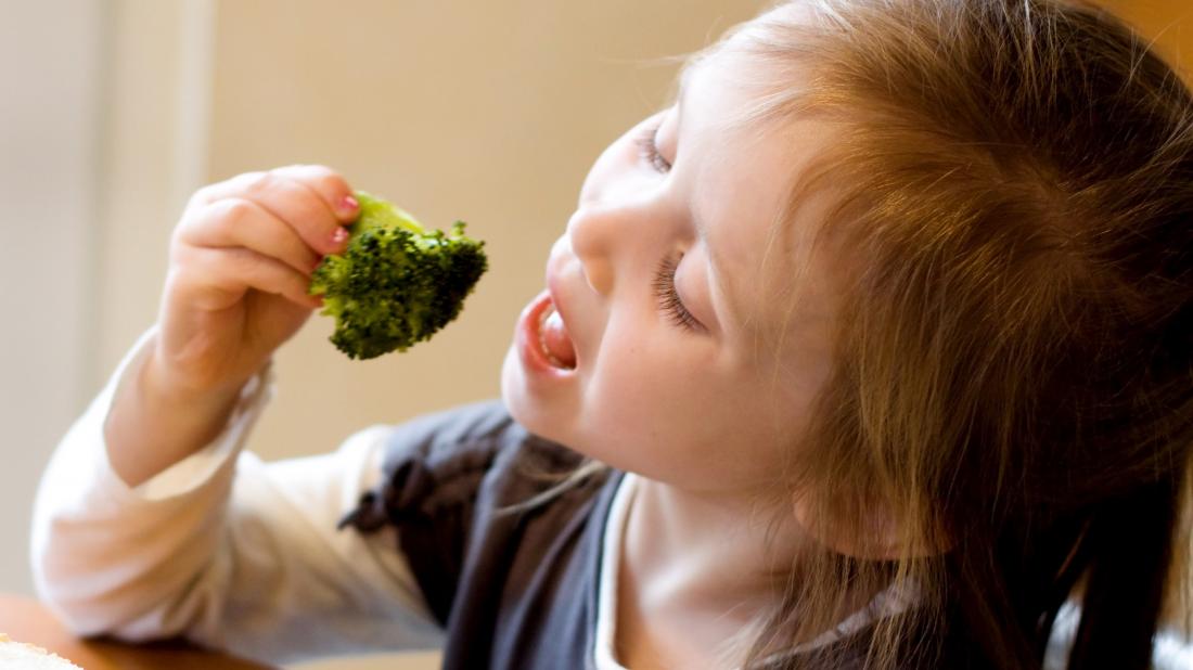 a child eating broccoli 
