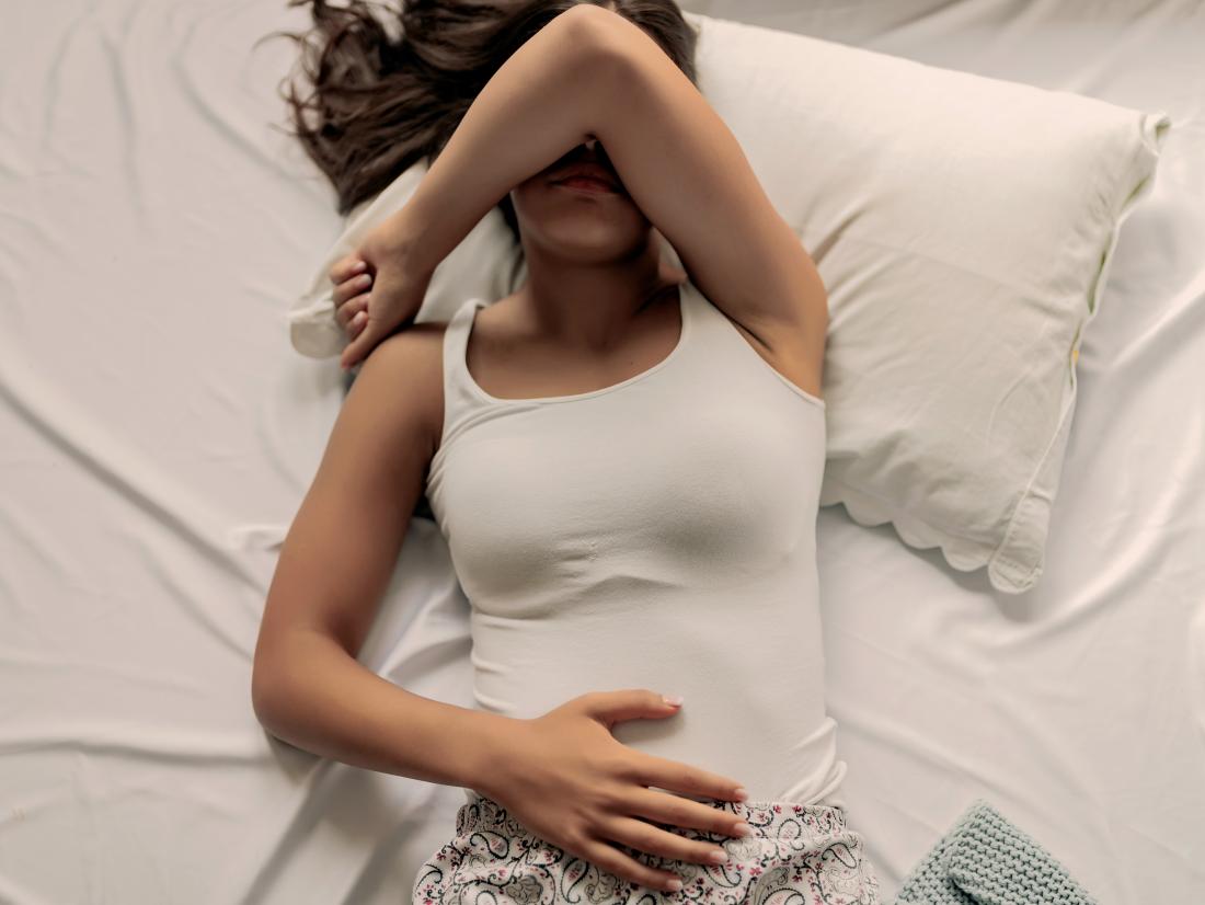 a woman in pain in her bed because of an irritated vulva