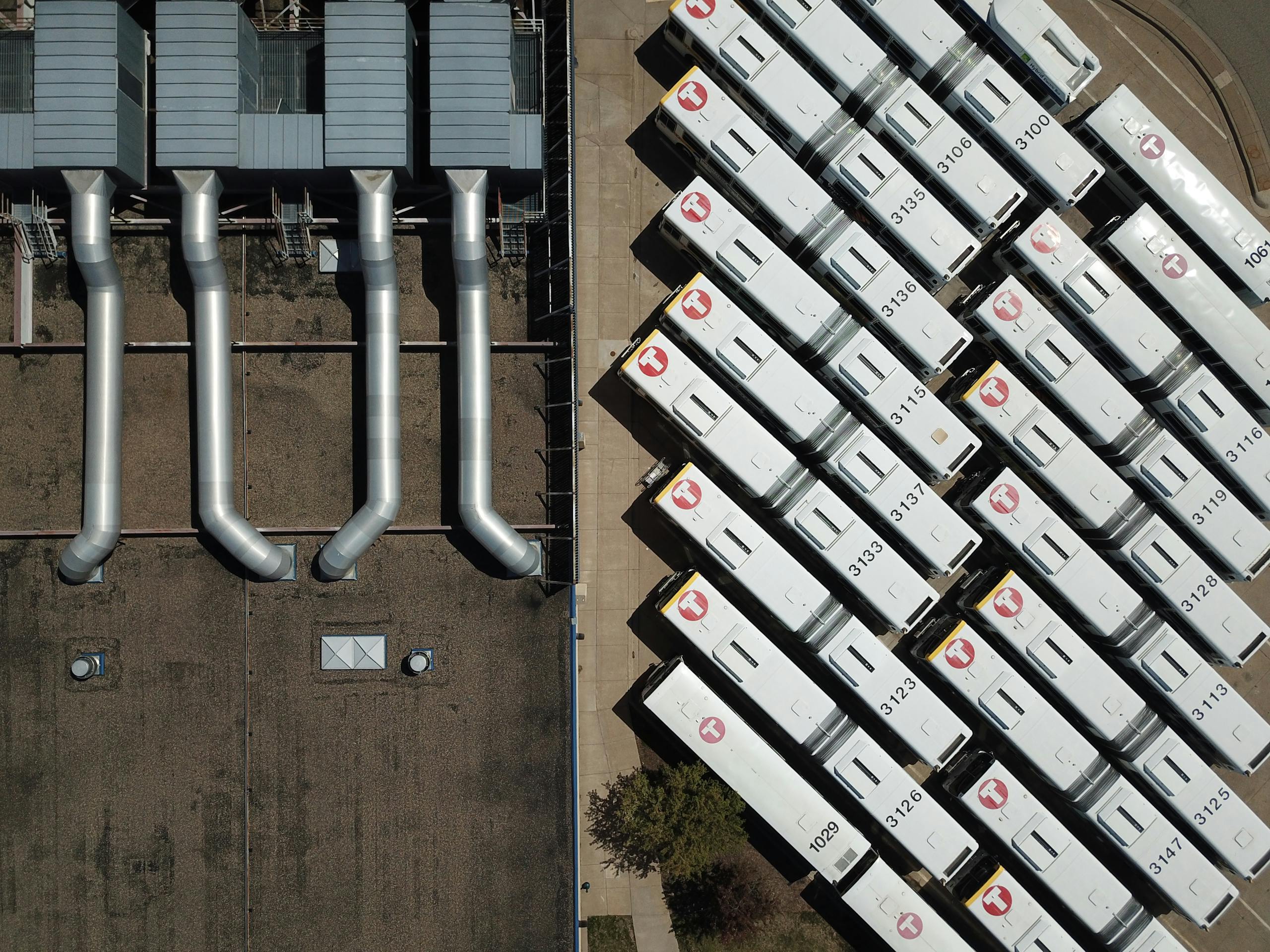 High-angle shot capturing buses and industrial HVAC systems on a rooftop in Minneapolis.