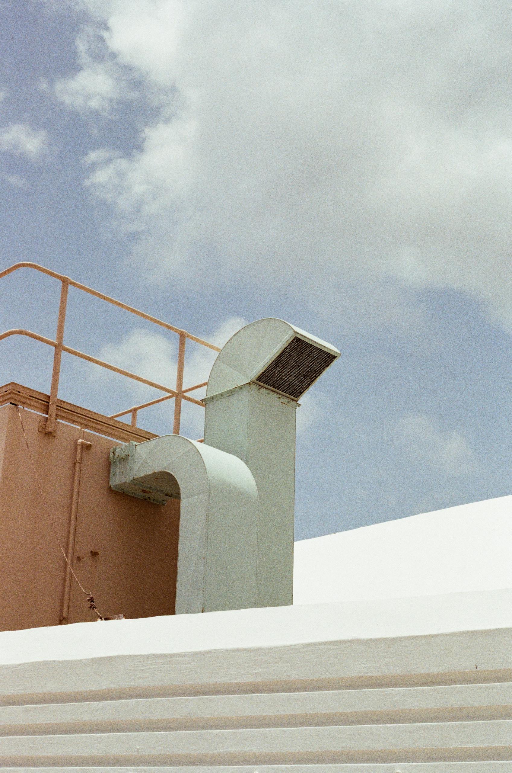 Roof ventilation system with a background of blue and cloudy sky.