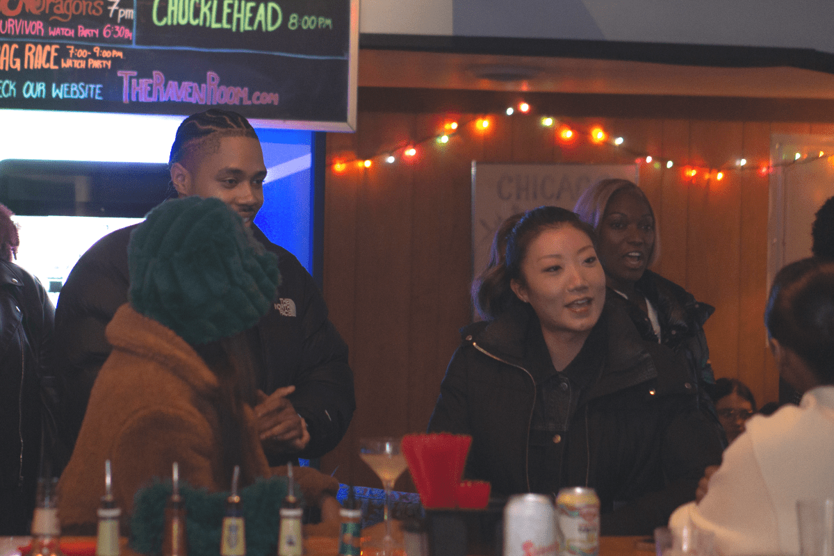 several patrons surround the bar at Raven Room