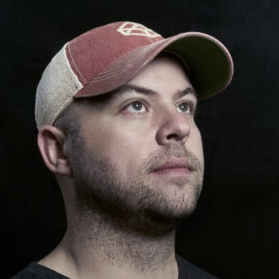 Photo of Chris Coyier. Red CodePen hat on, looking up and to the right.