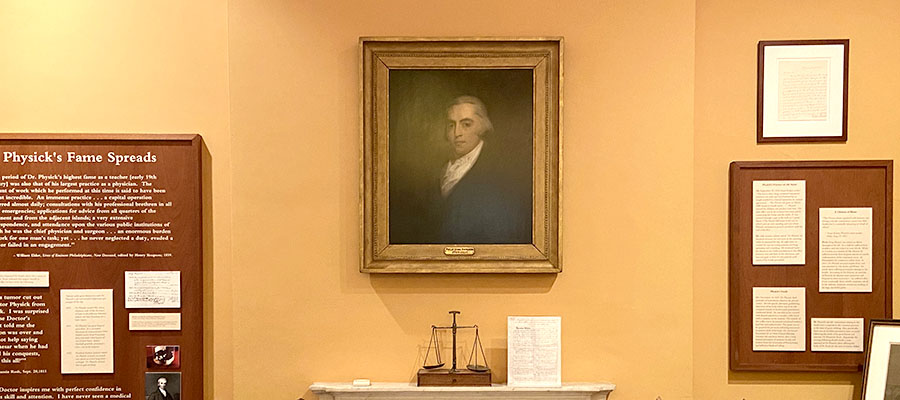 A photograph of a historic house museum room with a painted portrait over the mantle.