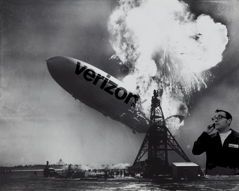 An image of the Hindenburg, mid-explosion. The Verizon logo has been added to the side of the doomed zeppelin. To its left looms the person of Paul Marcarelli in his guise as Verizon's 'test man' from the 'Can you hear me now?' ads.