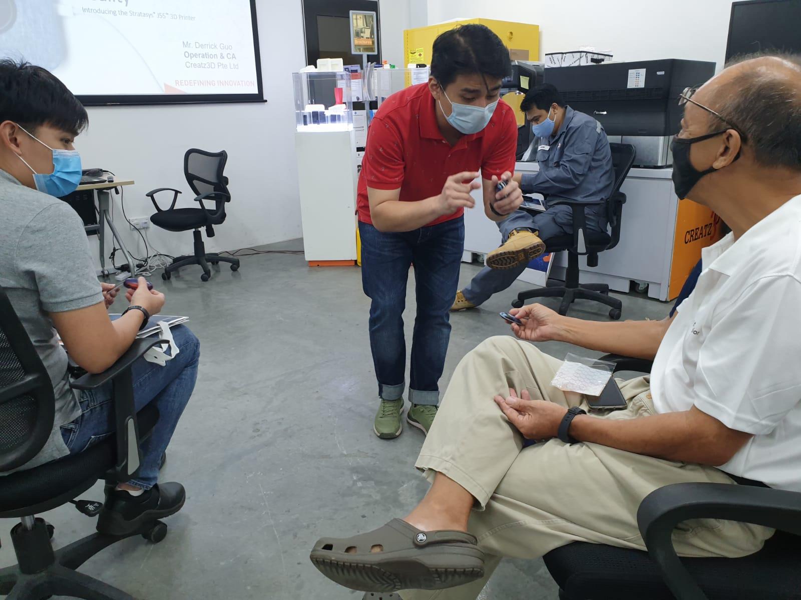 Showing attendees the 3D printed parts.