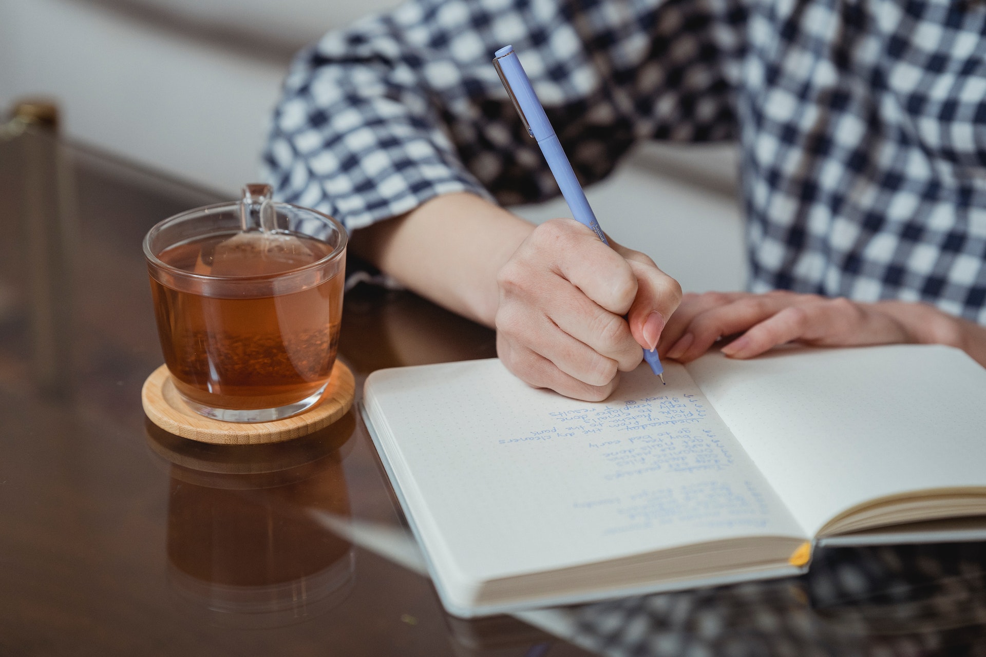 A scene of reflective journaling with a notebook and cup of tea