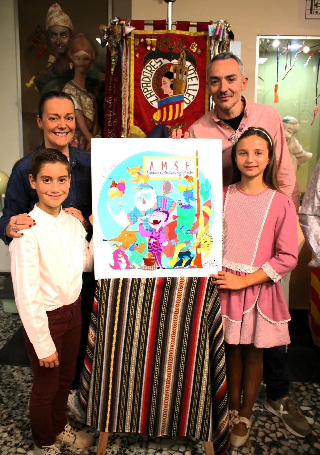 Descubre las Fallas que plantará la comisión de Zapadores-Vicente Lleó en 2024 2 Merche Faus, Ábgel Navarro, Fallera Mayor Infantil y Presidente Infantil junto al boceto de la Falla Infantil