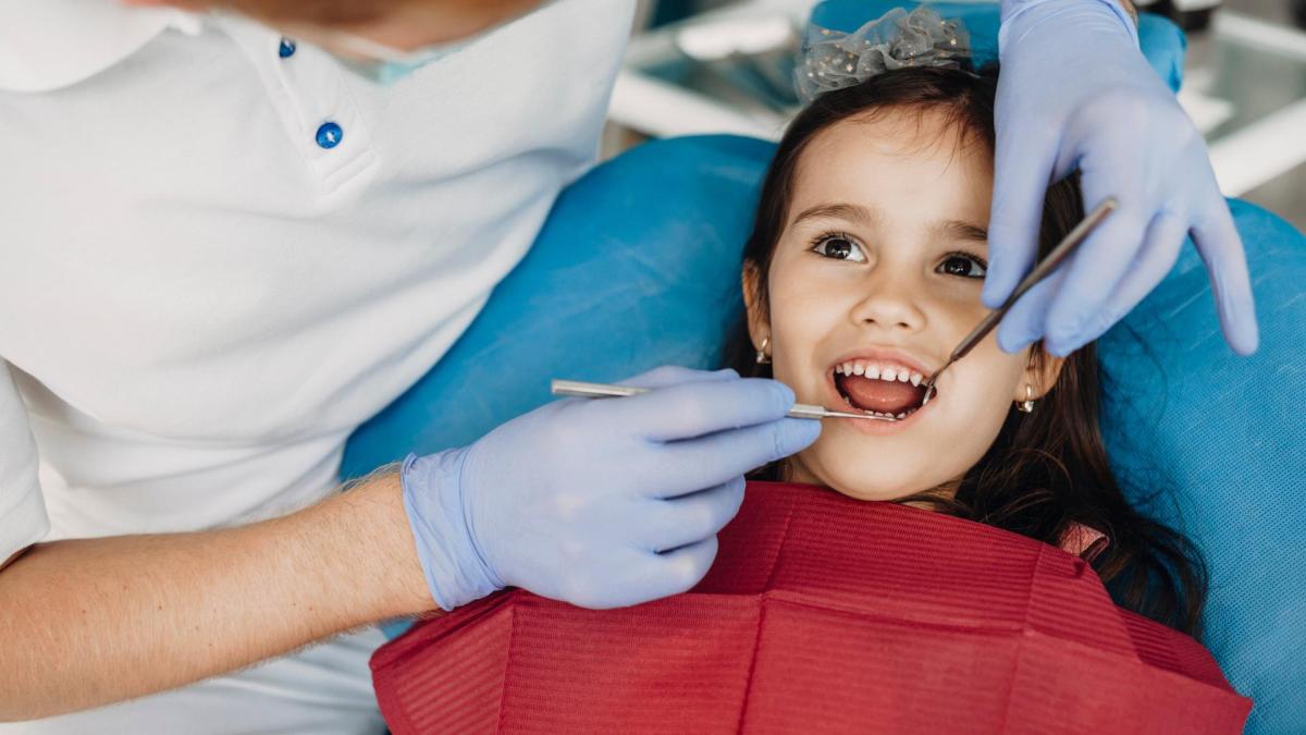 niña es atendida por una dentista en una clínica dental gratuita
