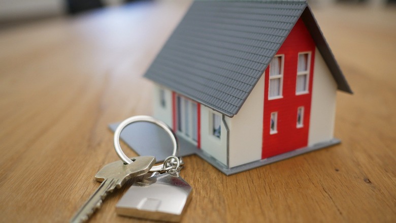 A toy house and a set of keys on a table.