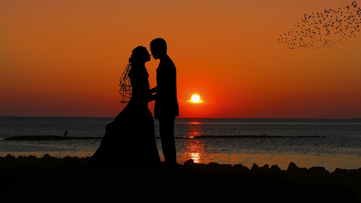 Bride and groom on beach at sunset